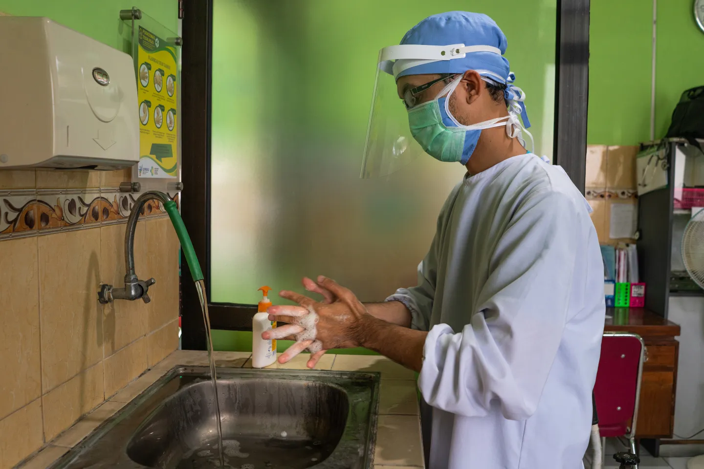 A doctor washing his hands with soap and running water in the Tegalrejo Community Health Centre in Yogyakarta, Indonesia.