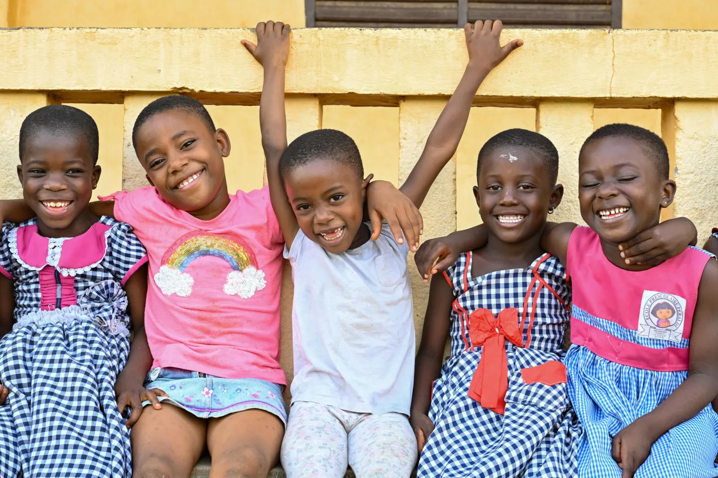 A group of happy children sitting together in a schoolyard.