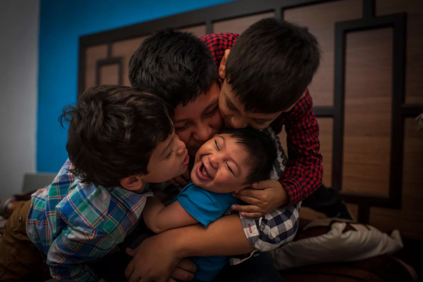 9-month-old Danilo, who has Congenital Zika Syndrome and microcephaly, laughs as his brothers shower him with kisses inside their home in Guatemala.