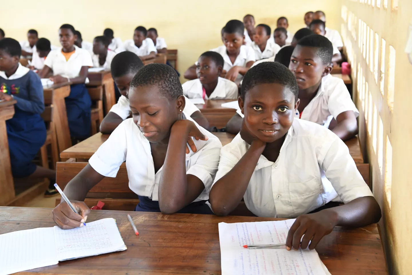 14-year-old Aminata Kona (right) attends class in the town of Man in the North West of C&ocirc;te d'Ivoire five months after giving birth to her son Chasika.