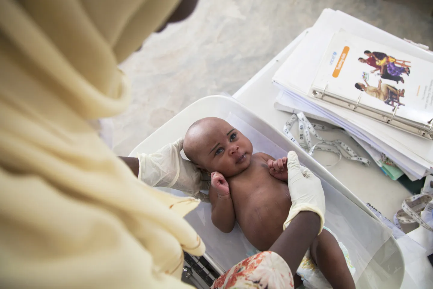 A baby is weighed at a health centre, Nigeria