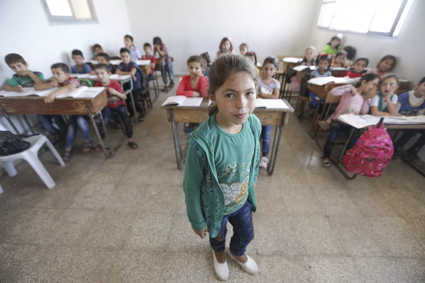A girl stands at the front of the classroom, Idlib