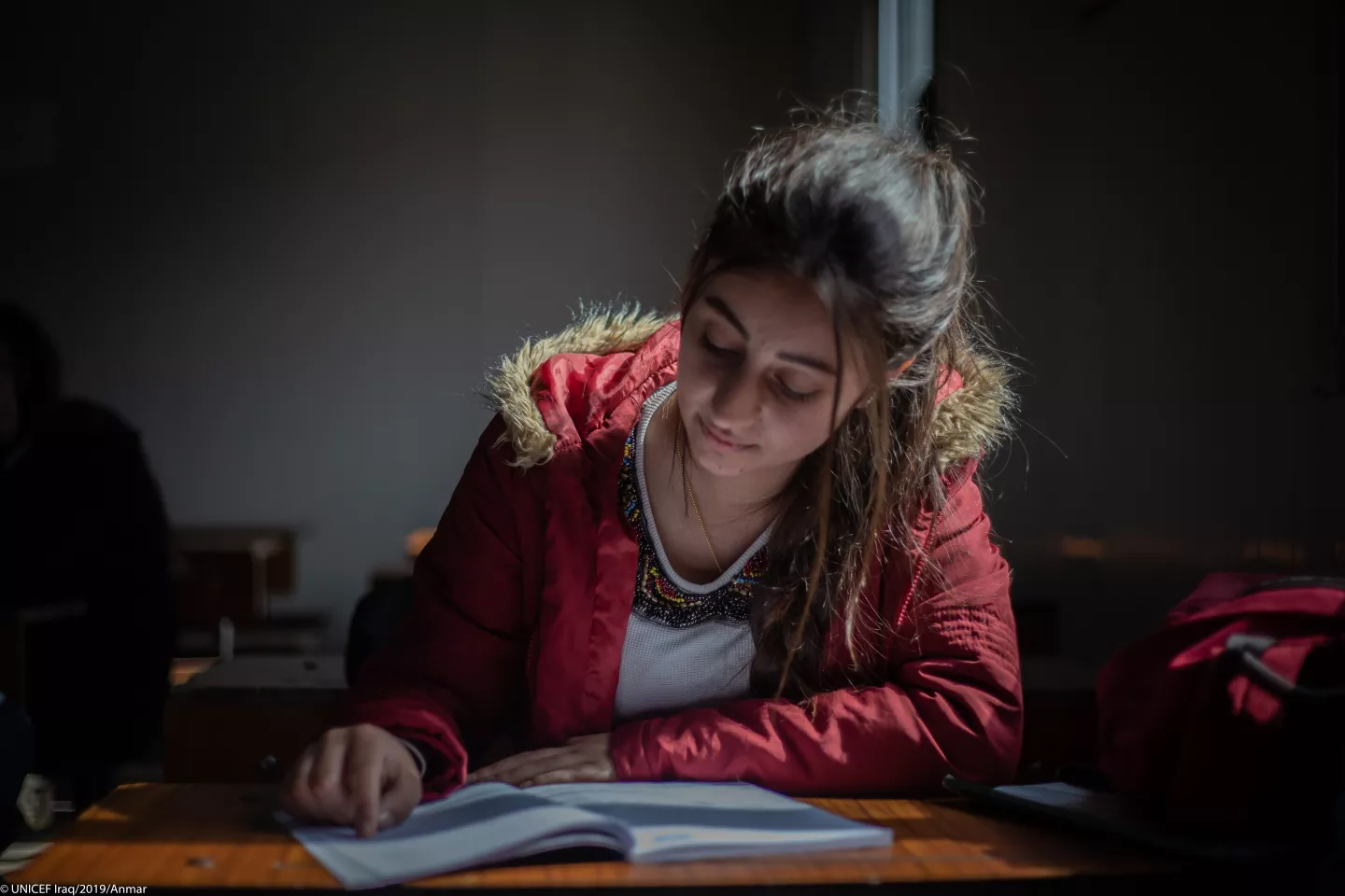 A girl writes at a desk