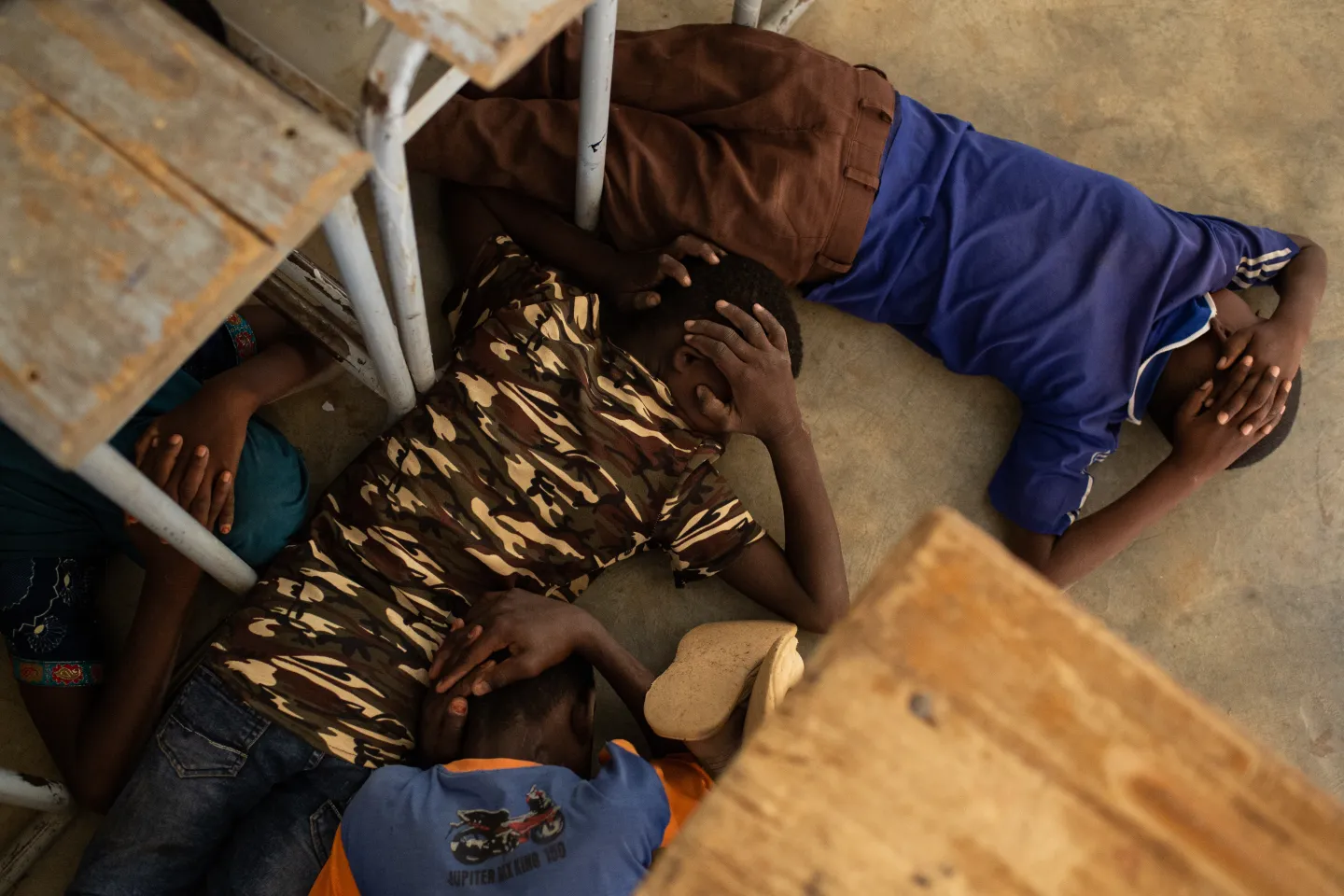 Burkina Faso. Children hide under desks.