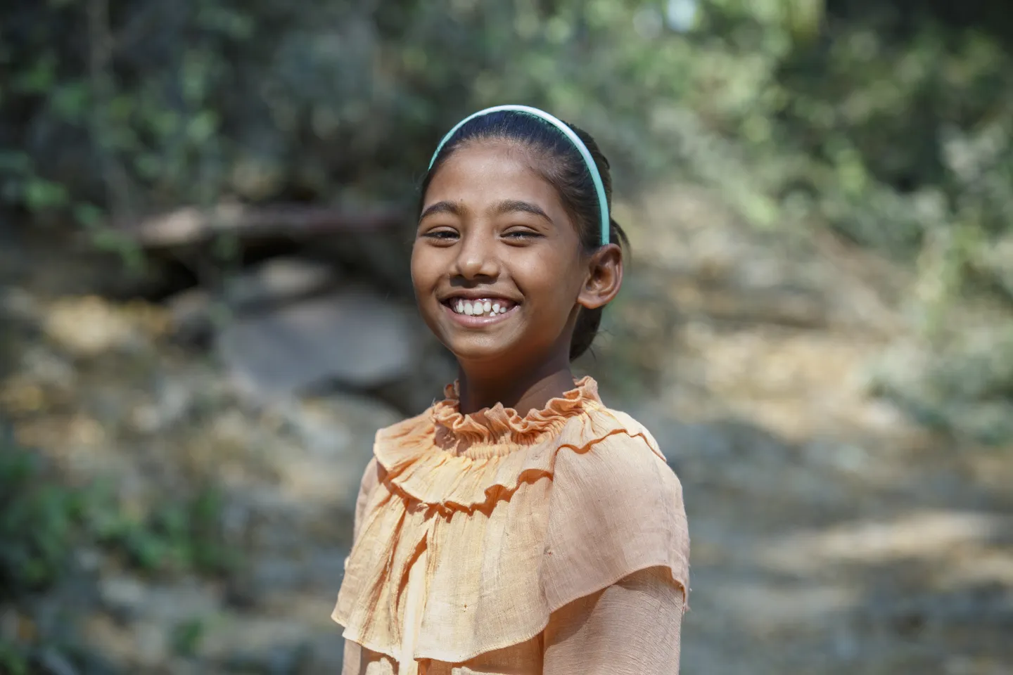 Pushpa, 11, smiling to the camera in Bangladesh.
