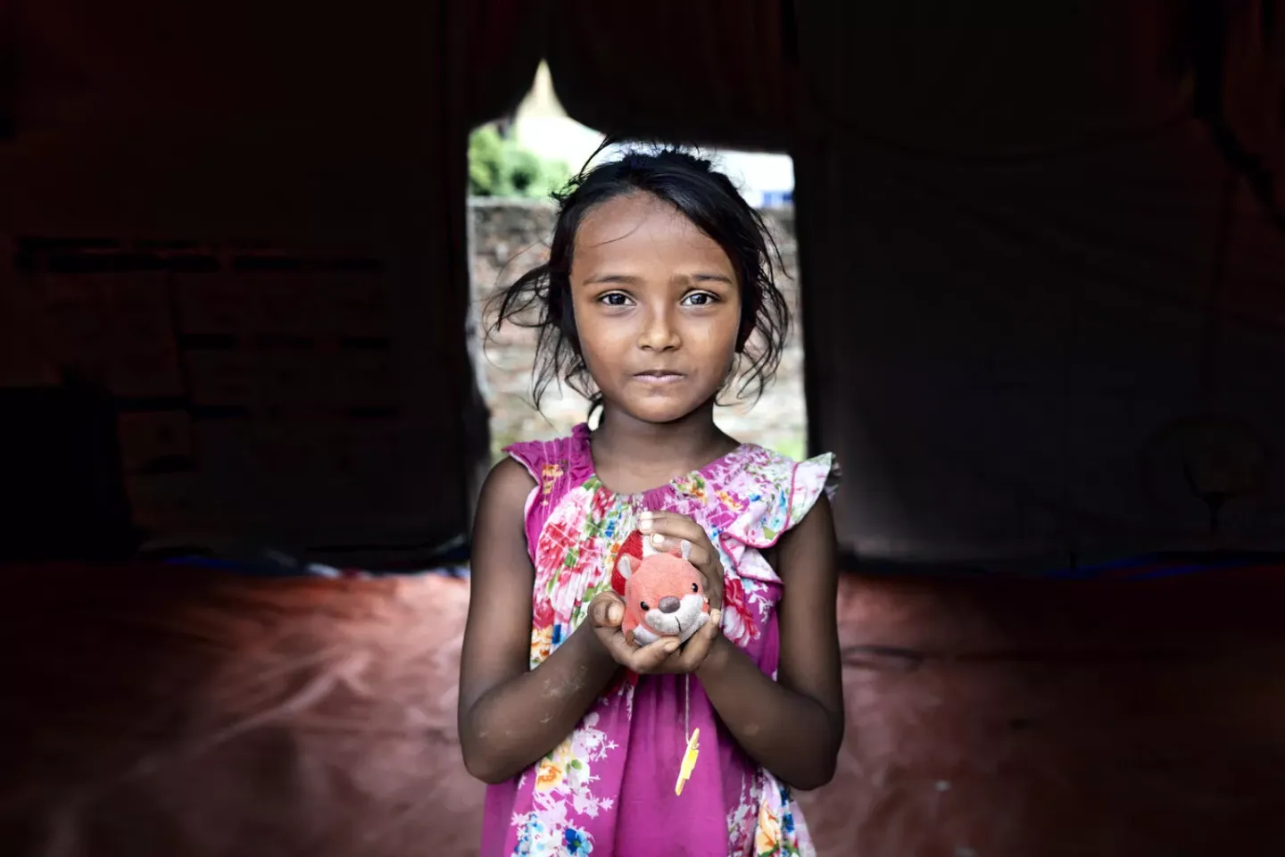 Meem (5) is holding her toy by standing inside the Child protection hub supported by Unicef.