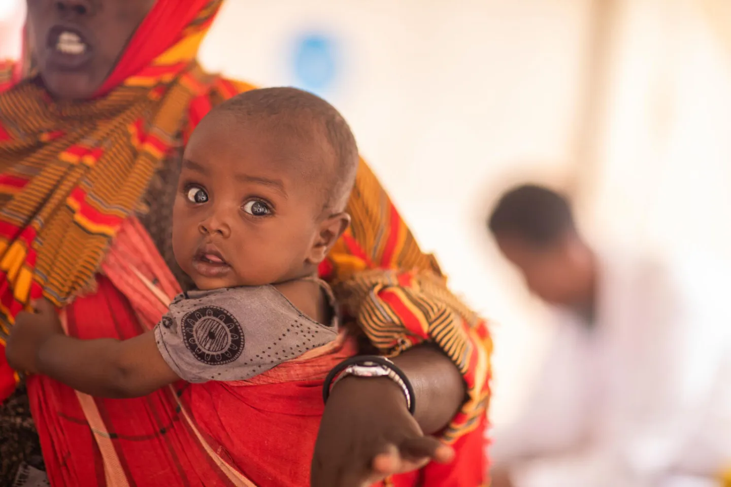 photo of a child carried by a woman