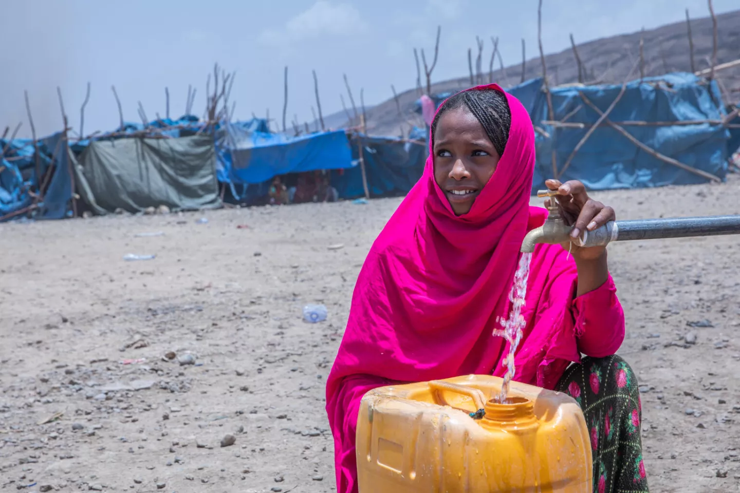 A girl fills a jerry can with water, Ethiopia