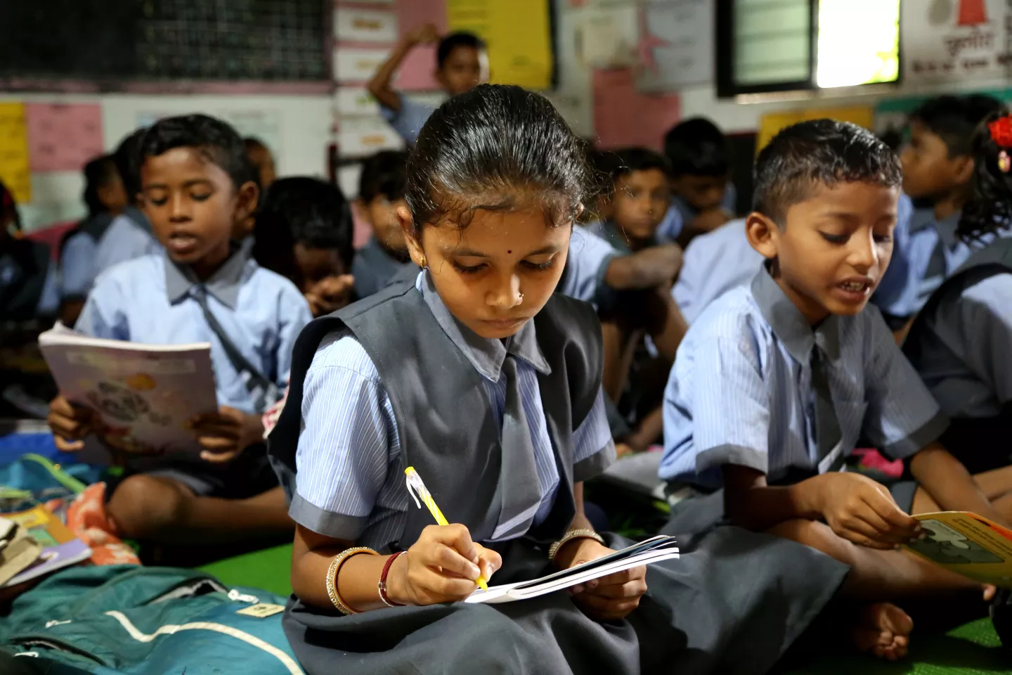 Avantika, de nueve a&ntilde;os, fotografiada mientras escribe en su sal&oacute;n de clases en India.