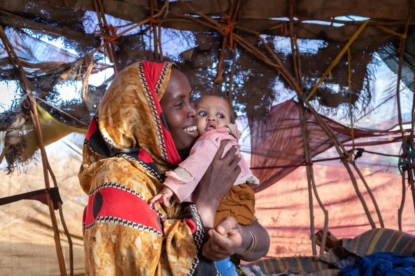Ethiopia. A woman holds her child in their makeshift shelter in Hargelle district, Ethiopia.