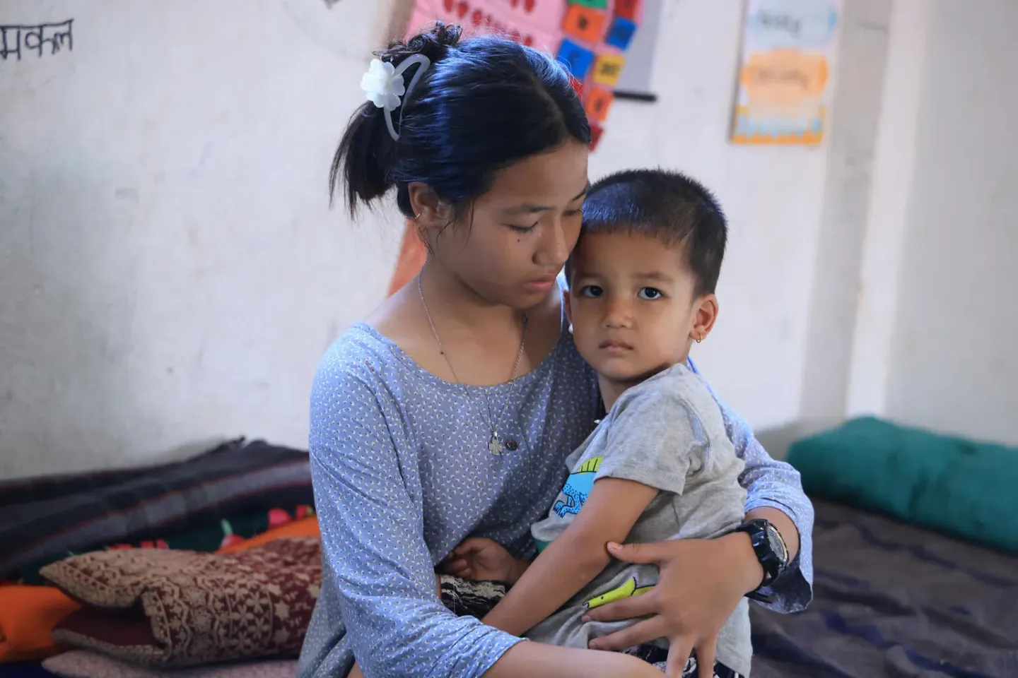 A 13 year old girl holds her younger brother after escaping a flashflood in Nepal.