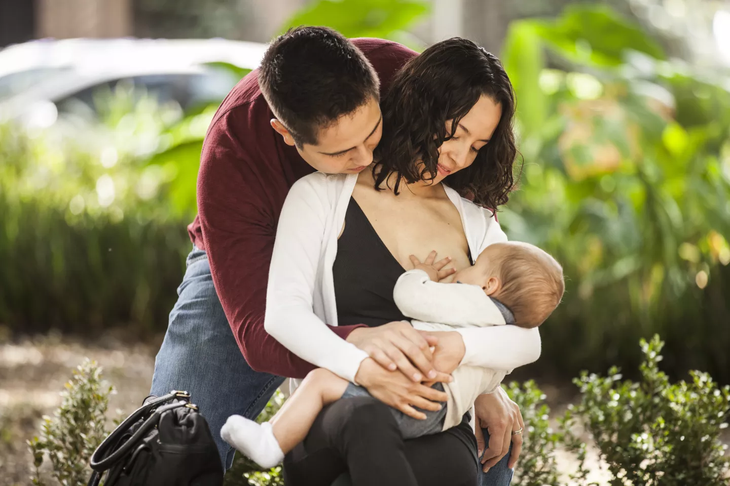 A man supports a woman breastfeeding her child, Mexico