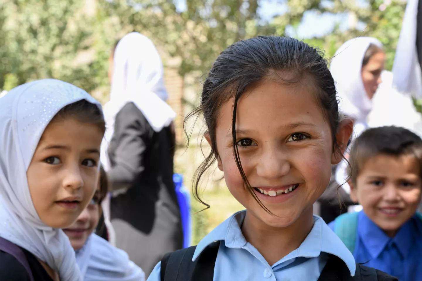 Schoolchildren in Afghanistan in 2019 smile at the camera.
