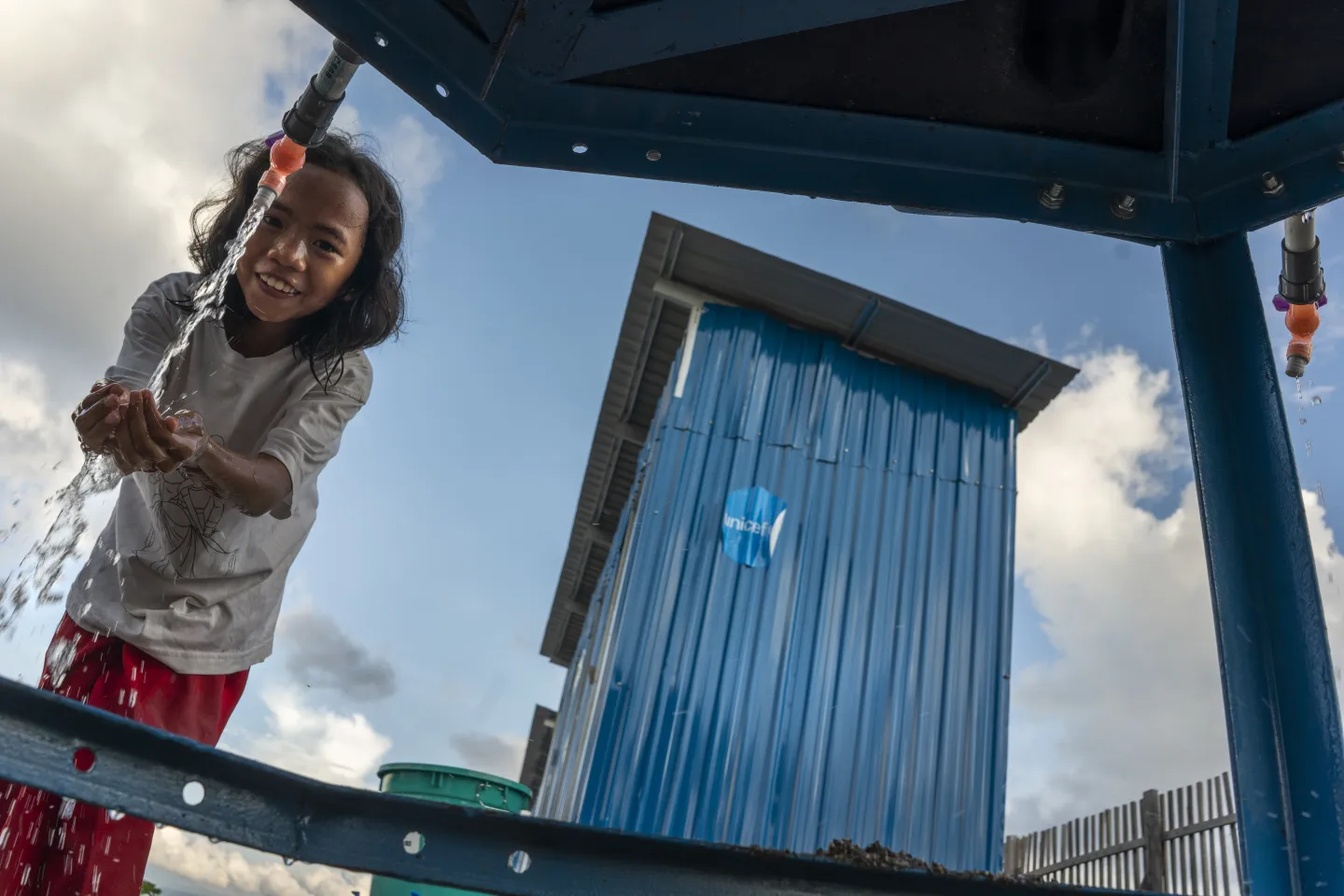 A girl washes her hands near toilets, Indonesia