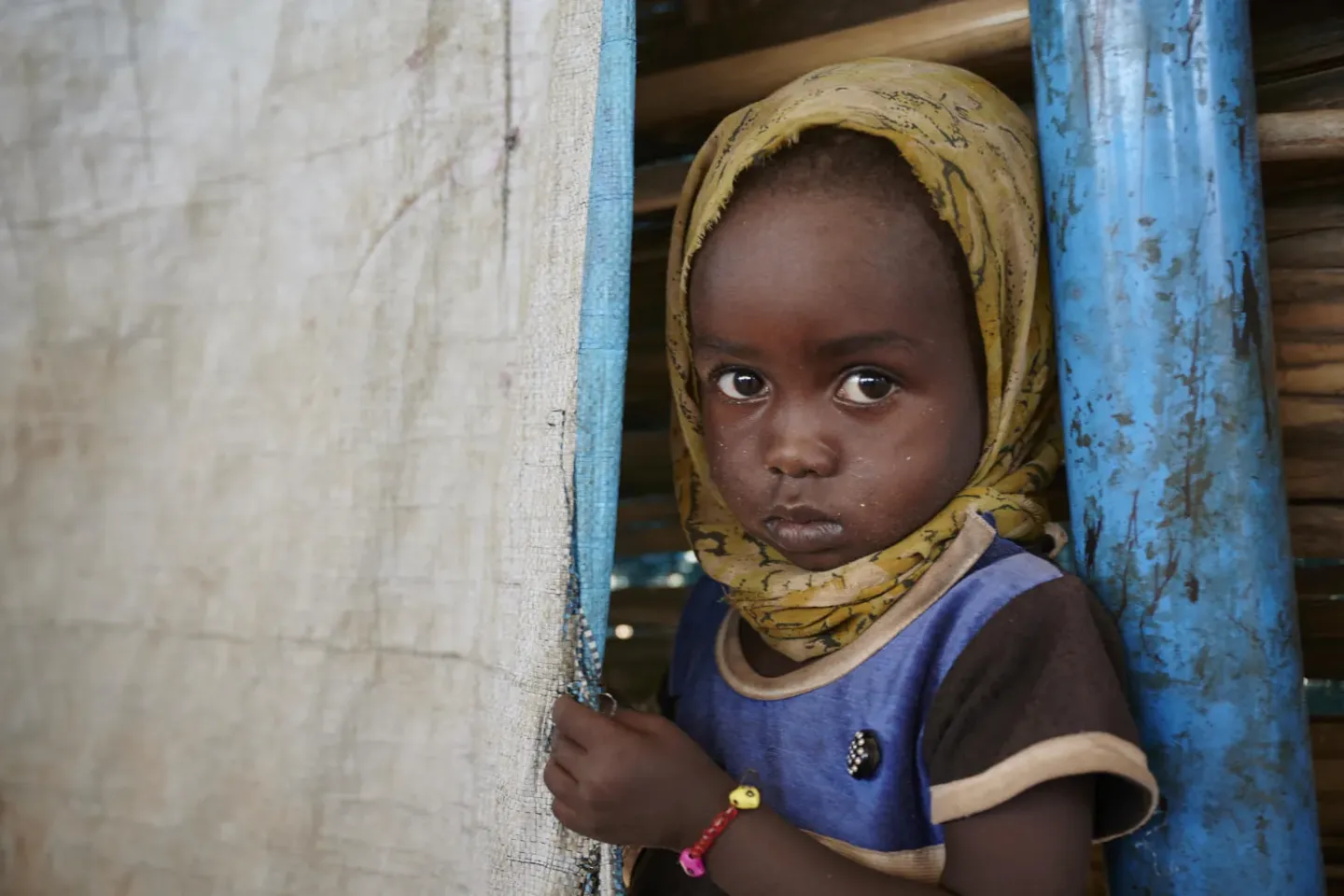 Sudan. A girl child stands at UNICEF-supported child-friendly space in a camp for displaced people.
