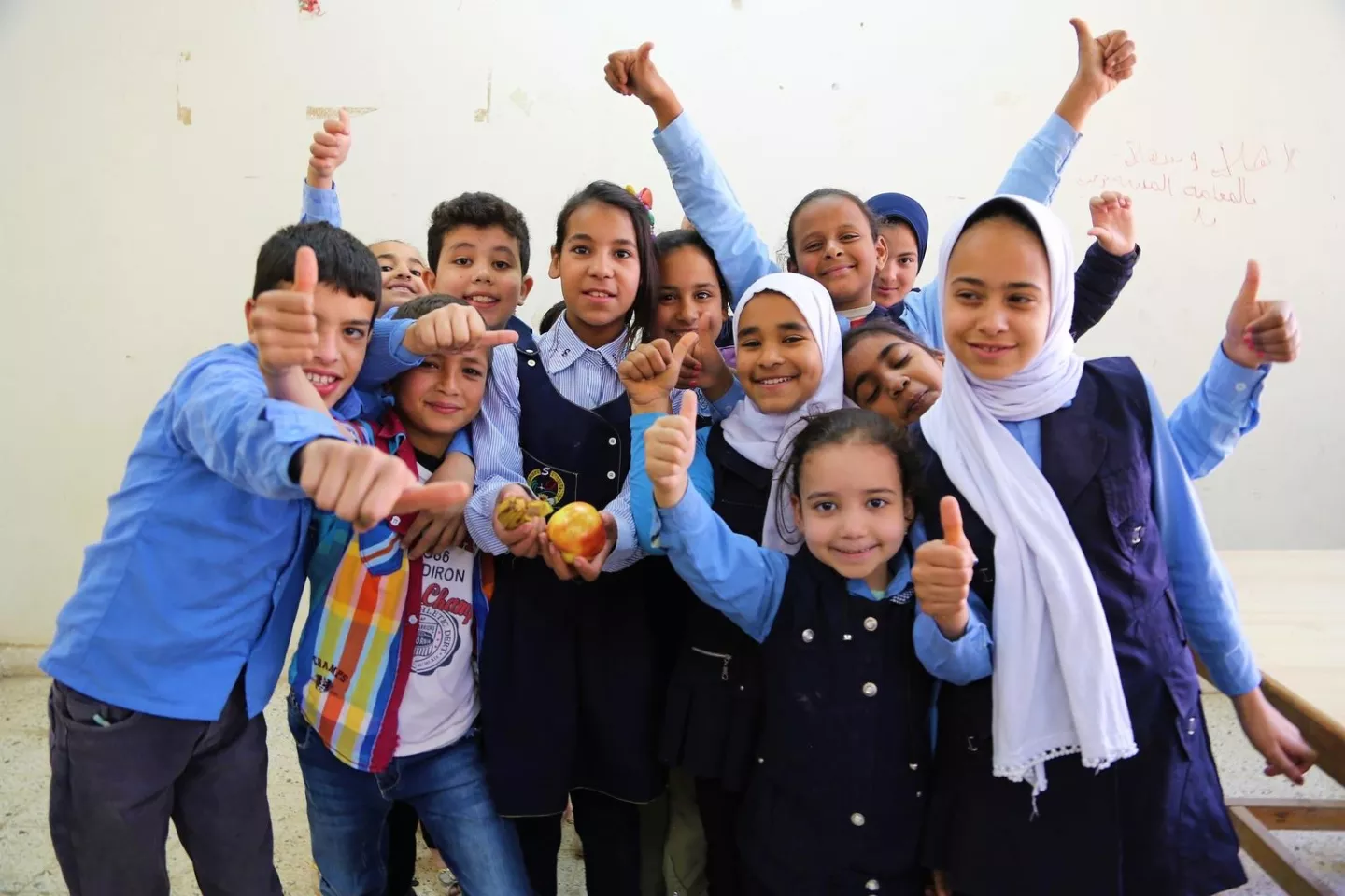 Children in Egypt raise their arms in joy in April 2019.