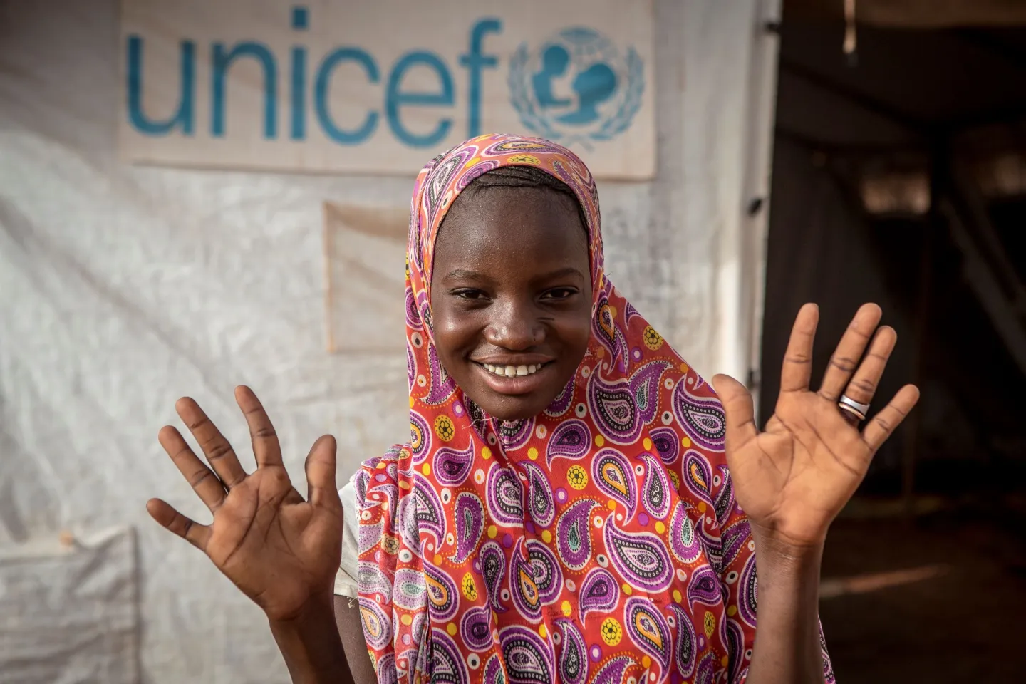 Mali. A teenager stands outside a tent.