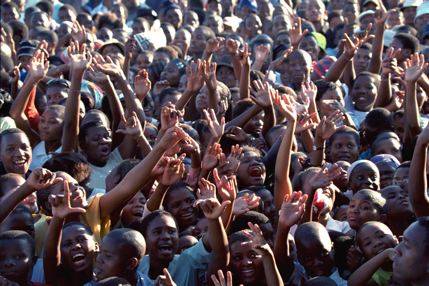 A crowd of youths, many of whom have come from areas beyond the village, raise their hands and sing at the opening ceremony of a 'loveLife Y Centre' in the village of Mathulini in the province of KwaZulu-Natal. 