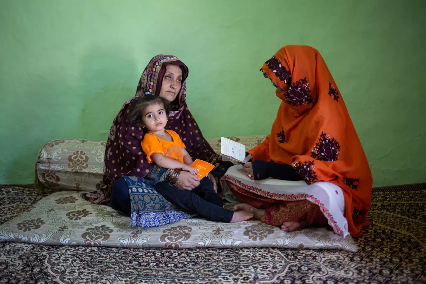 A lady healthworker speaks with a mother in Quetta, Balochistan province, Pakistan, encouraging her to ensure all her children are vaccinated.