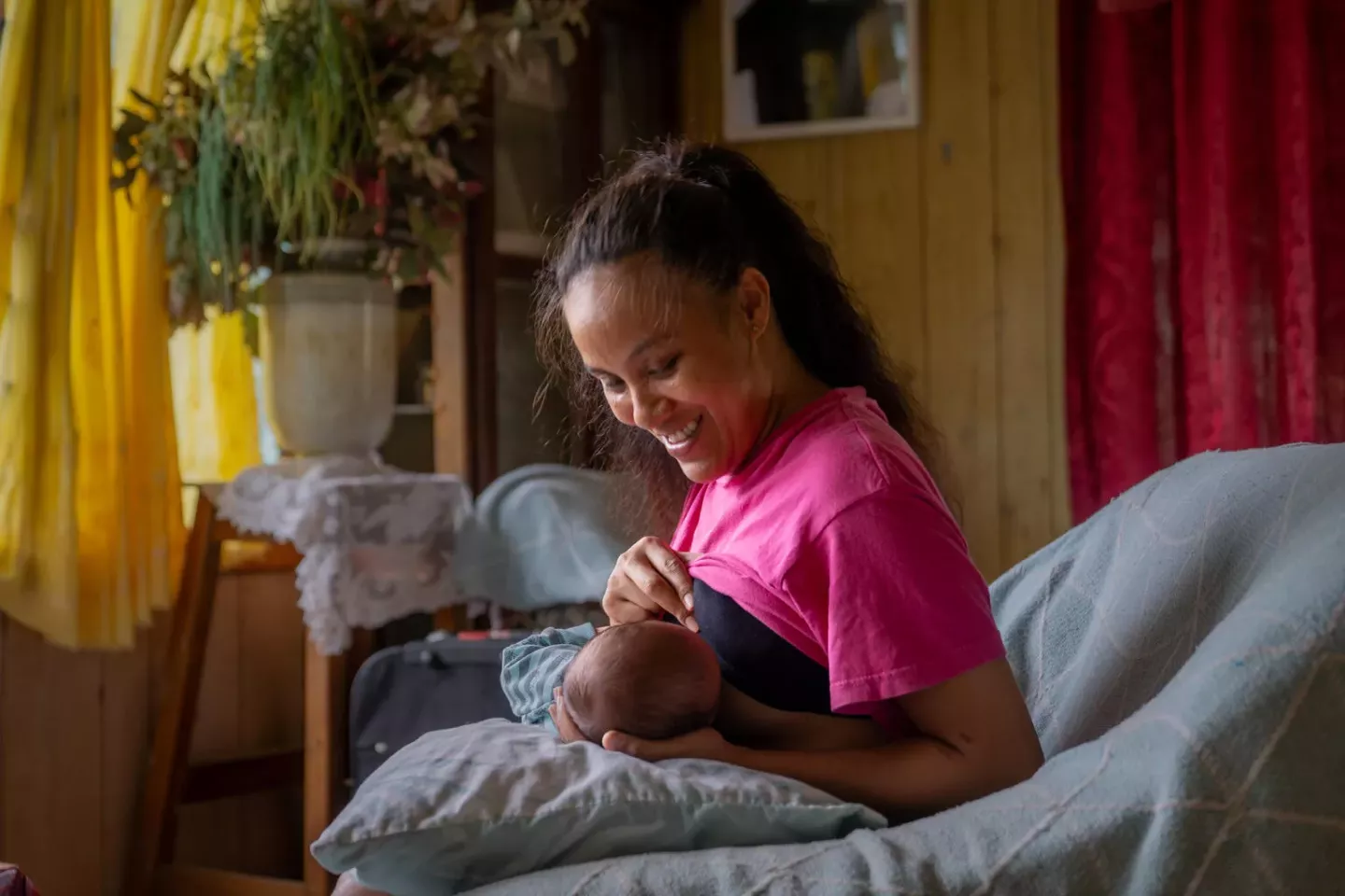 Tonga. A woman breastfeeds her baby.