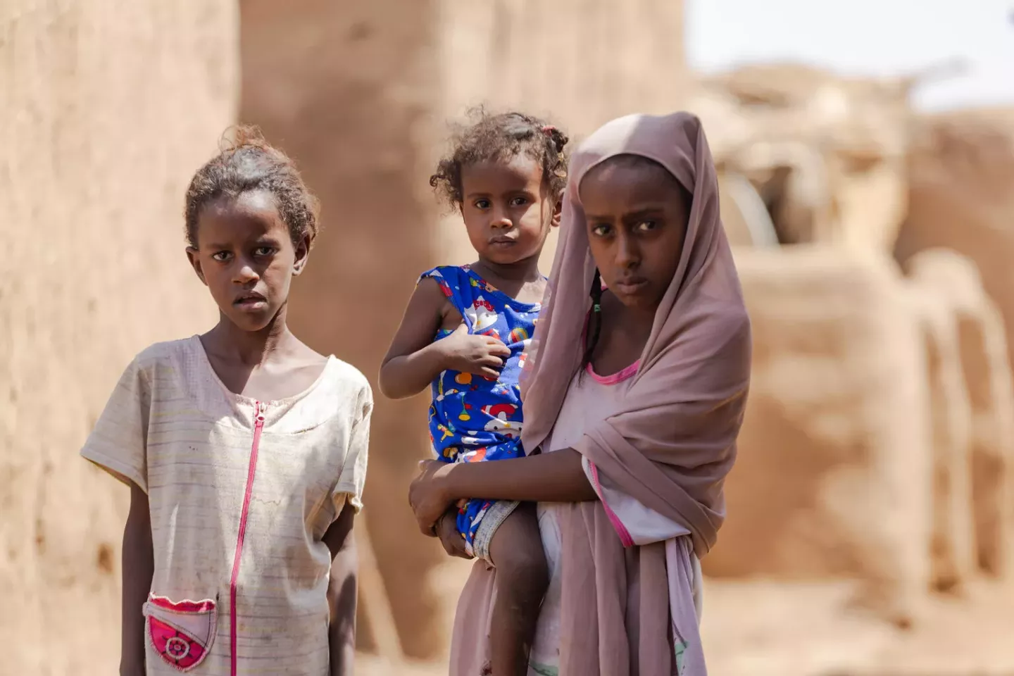 Sudan. A girl holds a young child in the Alsabaat community.