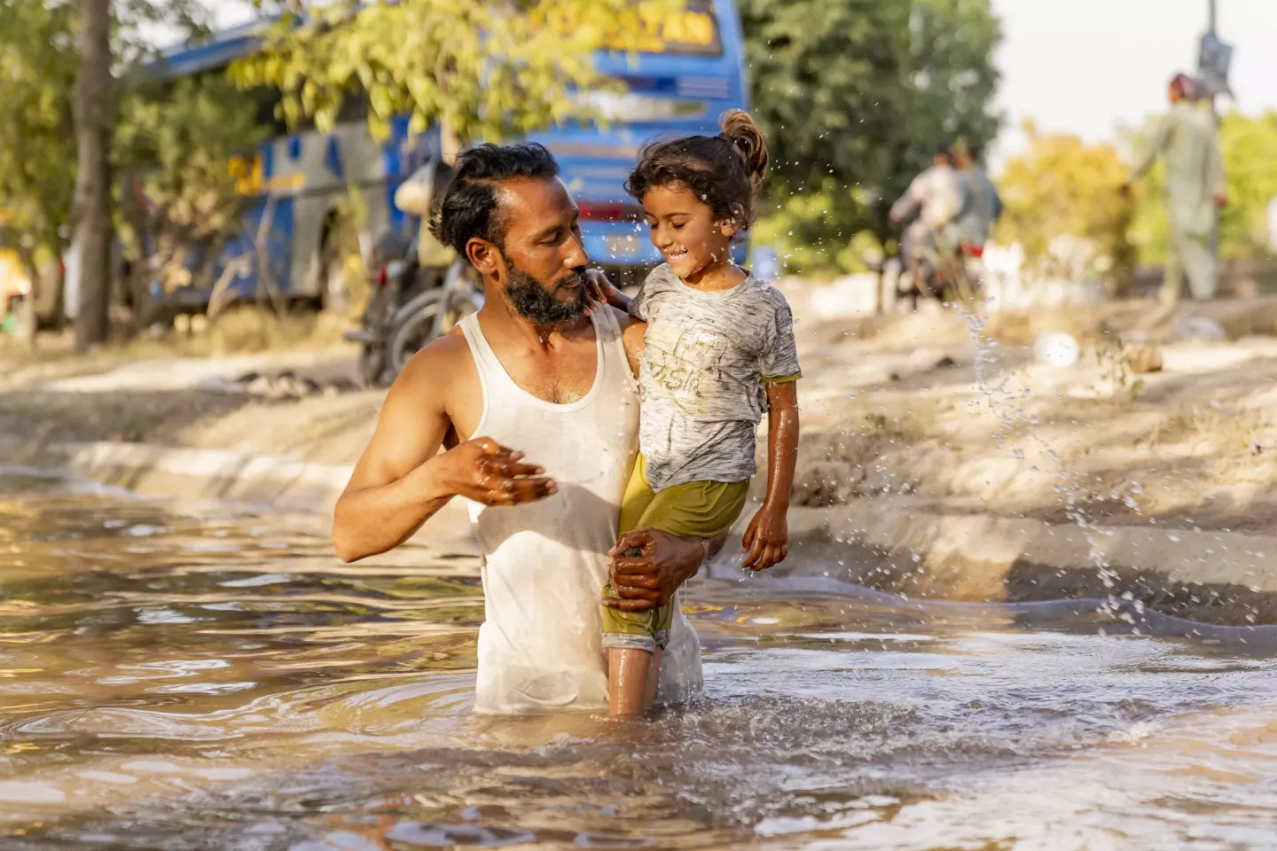 Muhammed Arshad shares a refreshing moment with his 4-year-old daughter, Ayesha, as they splash in the canal, finding relief from the heat on a scorching 47&deg;C day in Faisalabad, Pakistan..