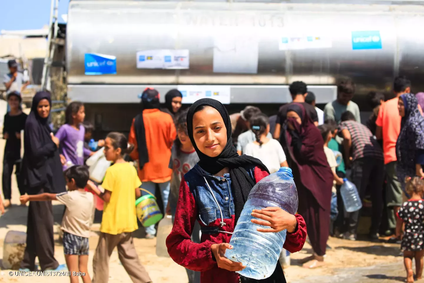 Gaza Strip. A girl holds a bottle of water after filling it at a UNICEF-supported water tank in the Gaza Strip.