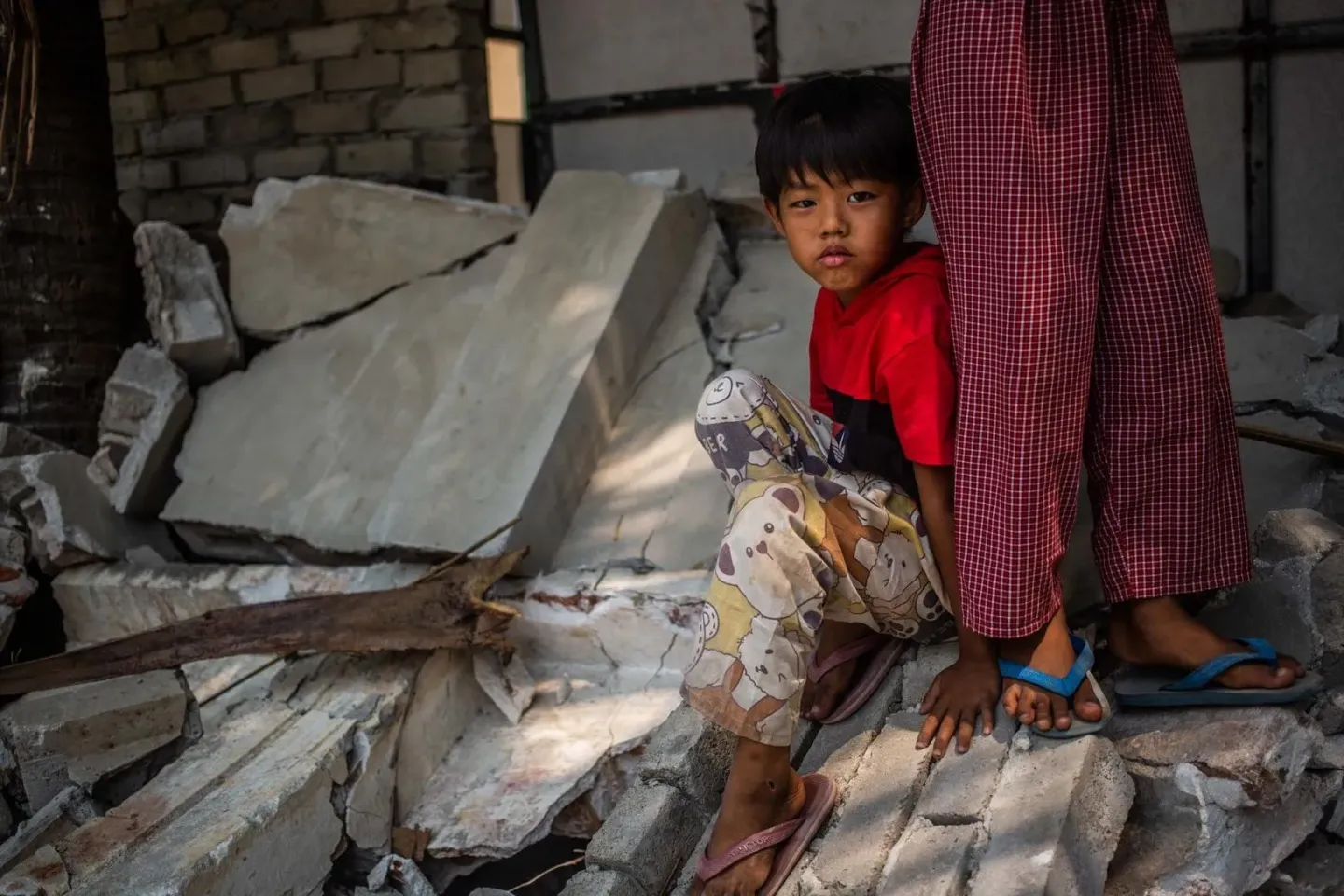Myanmar. A boy sits on part of a collapsed wall following an earthquake in Mandalay, Myanmar.
