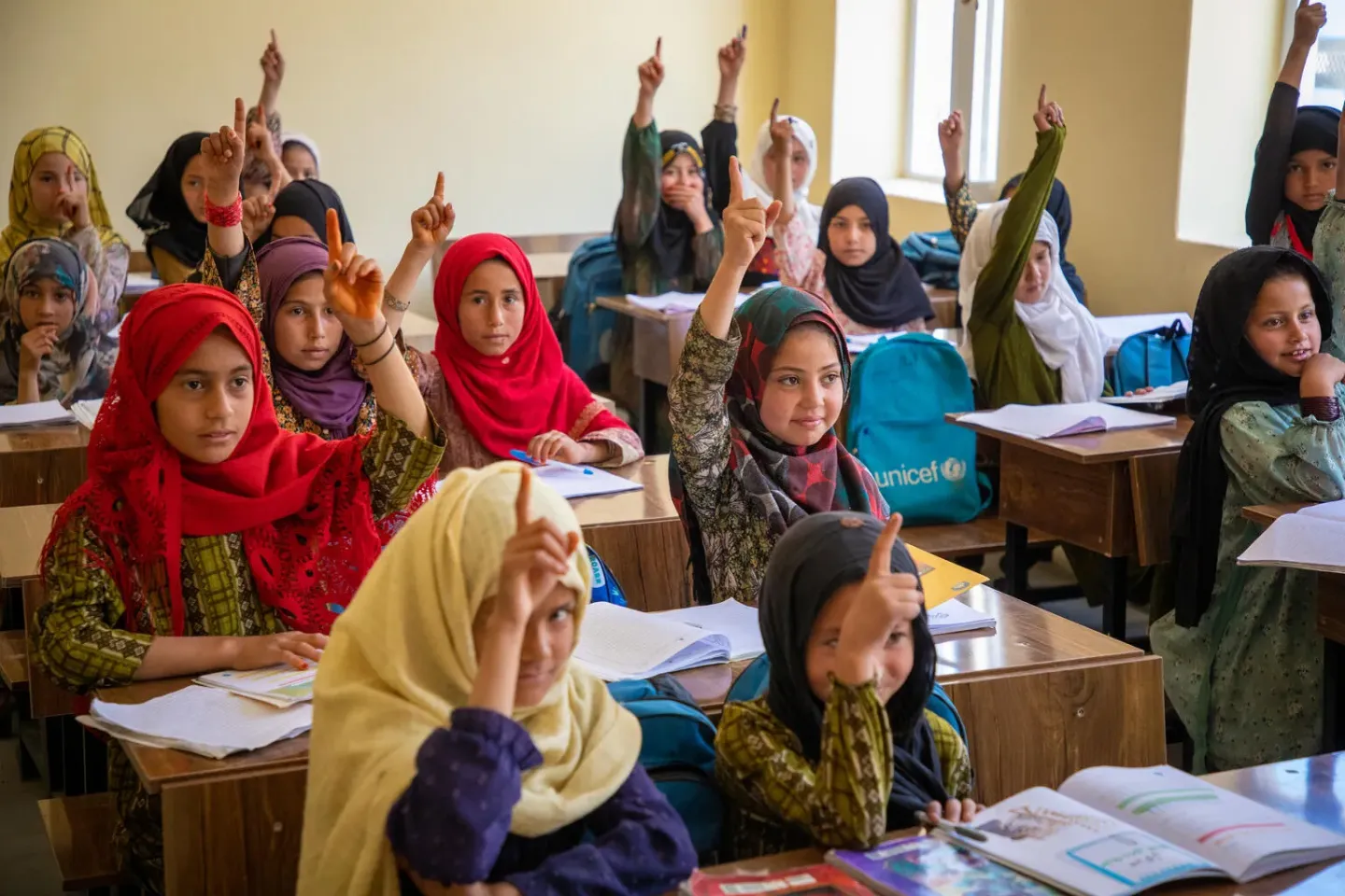 Girls raising hands in class.