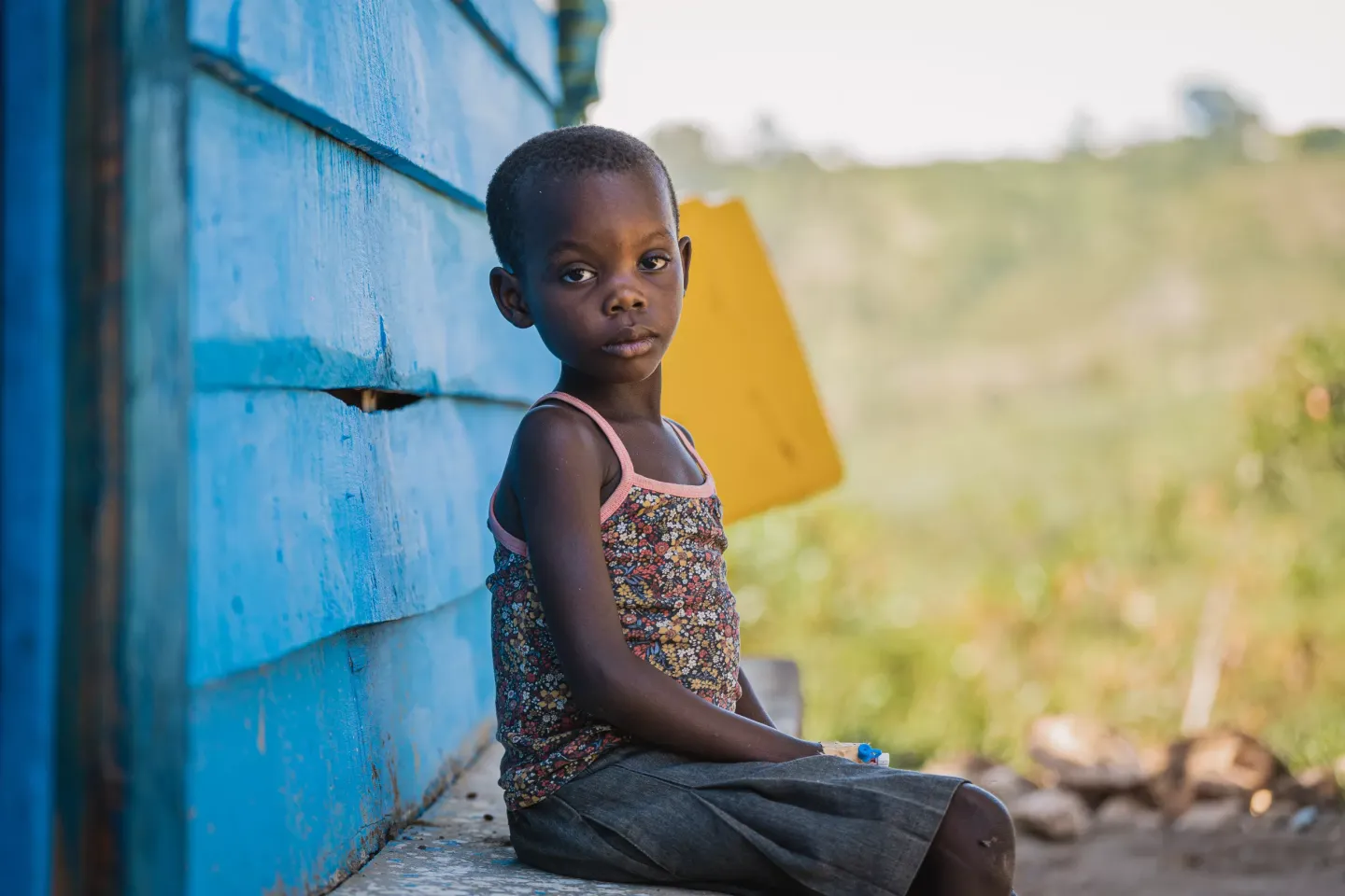 Una ni&ntilde;a de 7 a&ntilde;os sentada afuera de un centro de salud para pacientes de c&oacute;lera en Kihumba, Rep&uacute;blica Democr&aacute;tica del Congo.