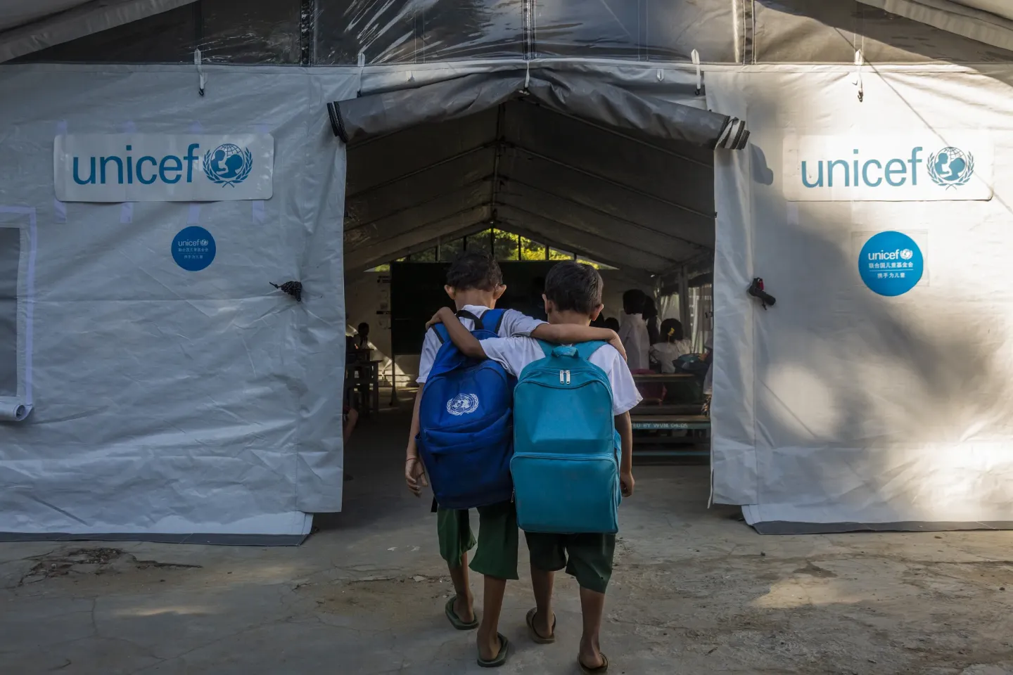 Myanmar. Two boys walk towards a newly installed tent classroom being used as temporary learning space after an earthquake damaged classrooms and school buildings in Mandalay Region, Myanmar.