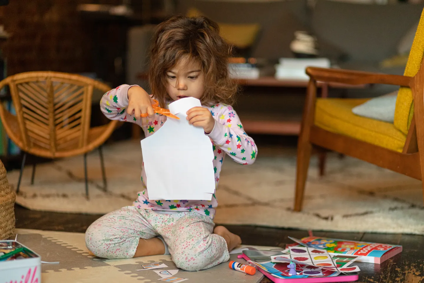 A girl sitting on the floor doing arts and crafts