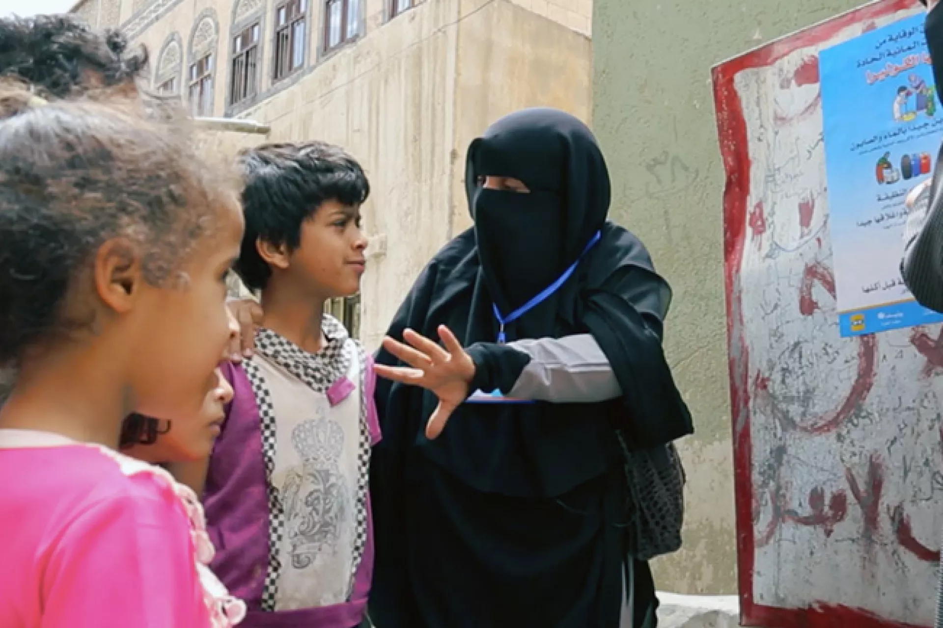 Fathya talks to children at a water point
