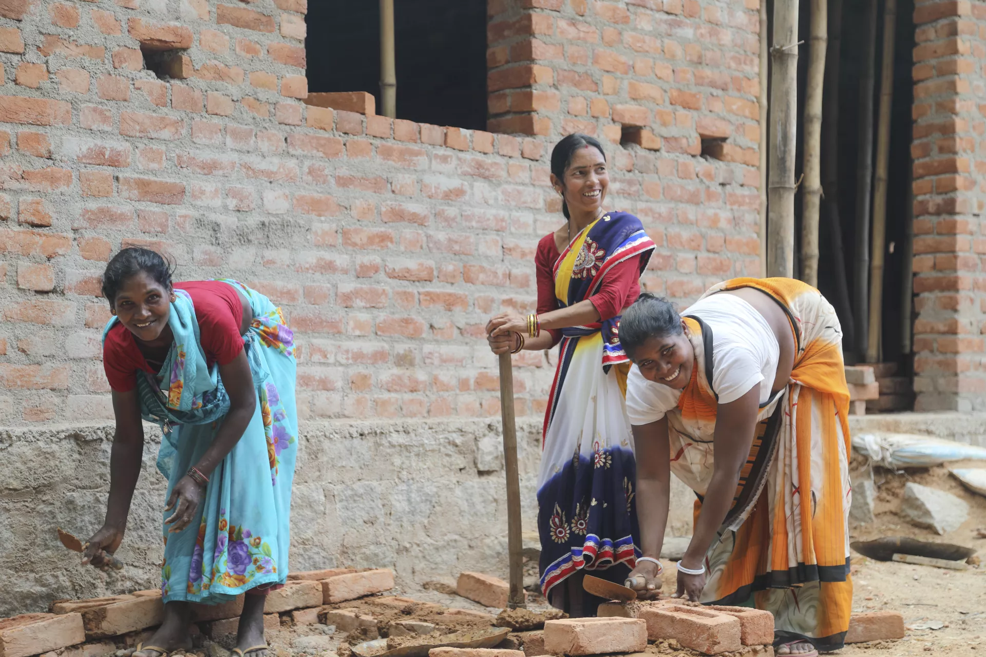 Women work on building a toilet in India