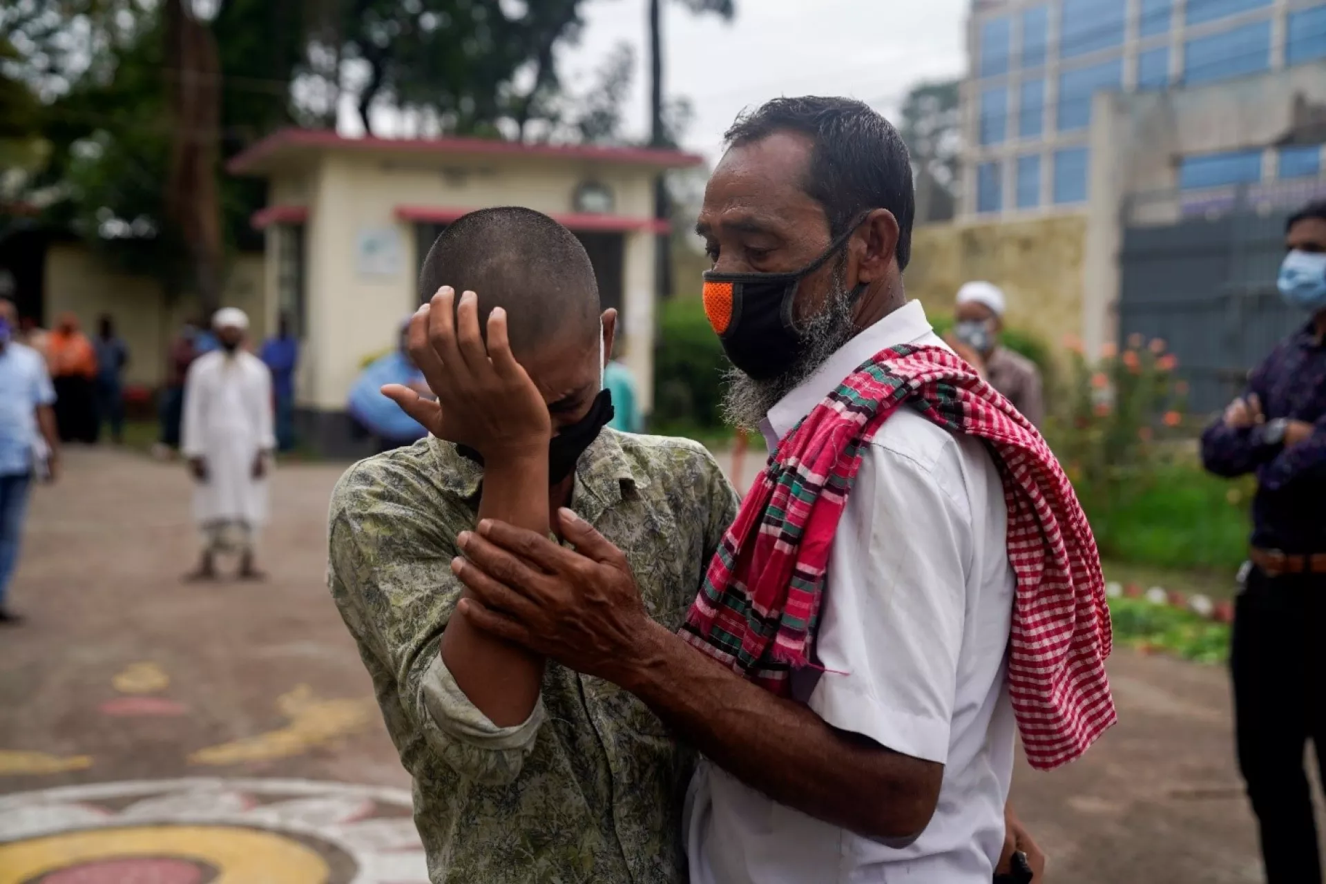 Bangladesh. A man stands with a teenager.