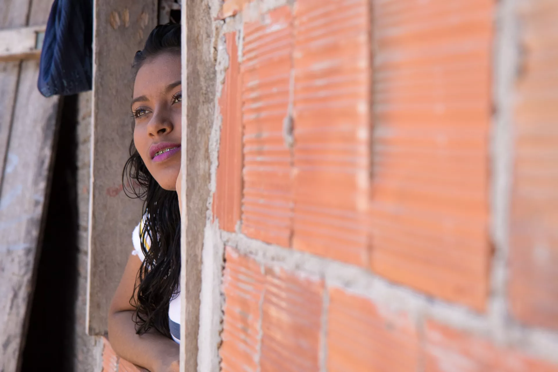 Maria Beatriz (Bia) Teixeira dos Santos looks out the window of her home.