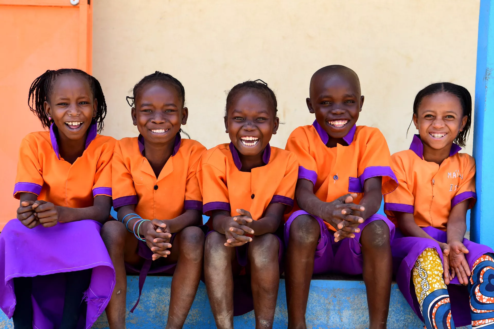 A group of children pose for a photo at the playground of the primary school