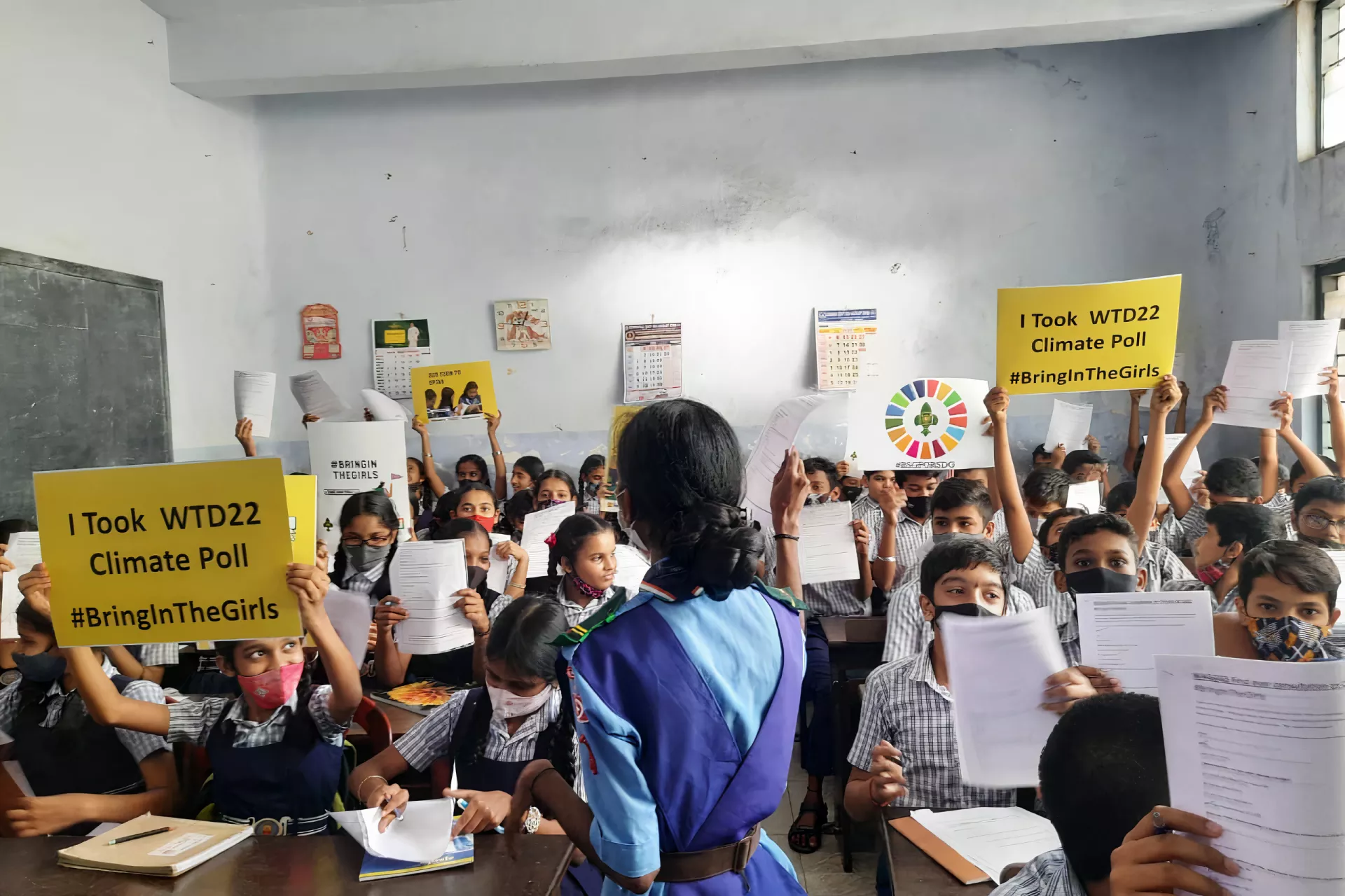 Young students in class, holding placards on Climate poll.