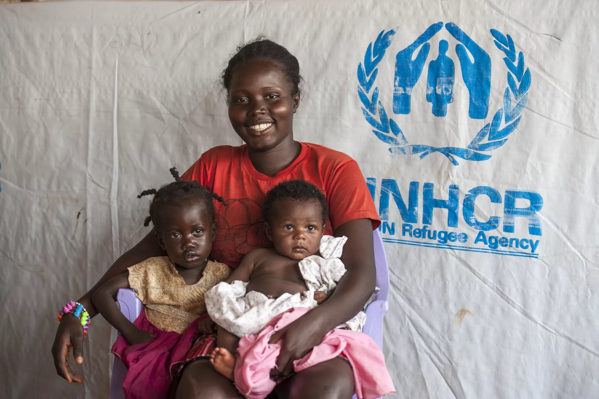 A woman sits with her children.