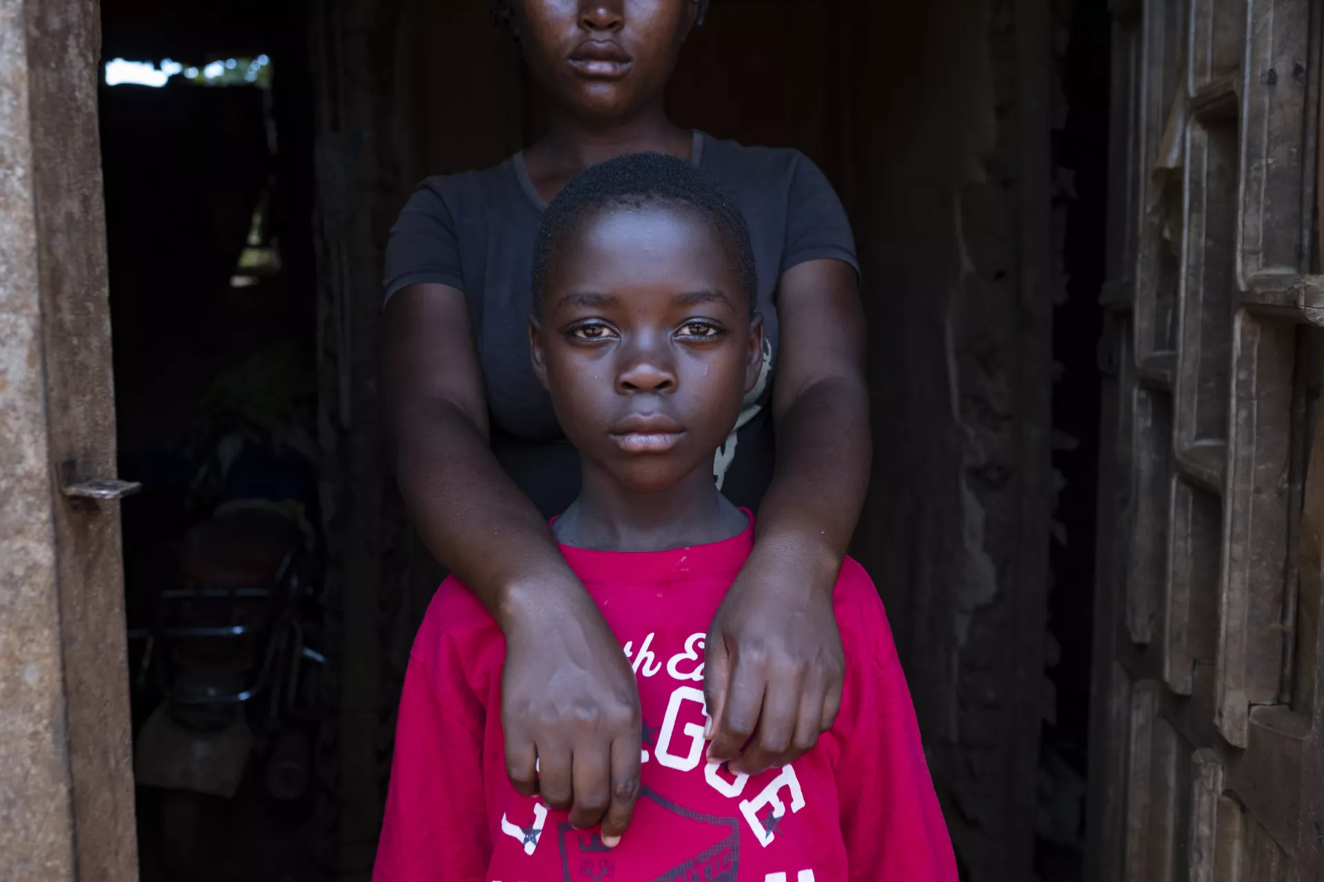 A girl wraps her arms around her sister, Democratic Republic of Congo