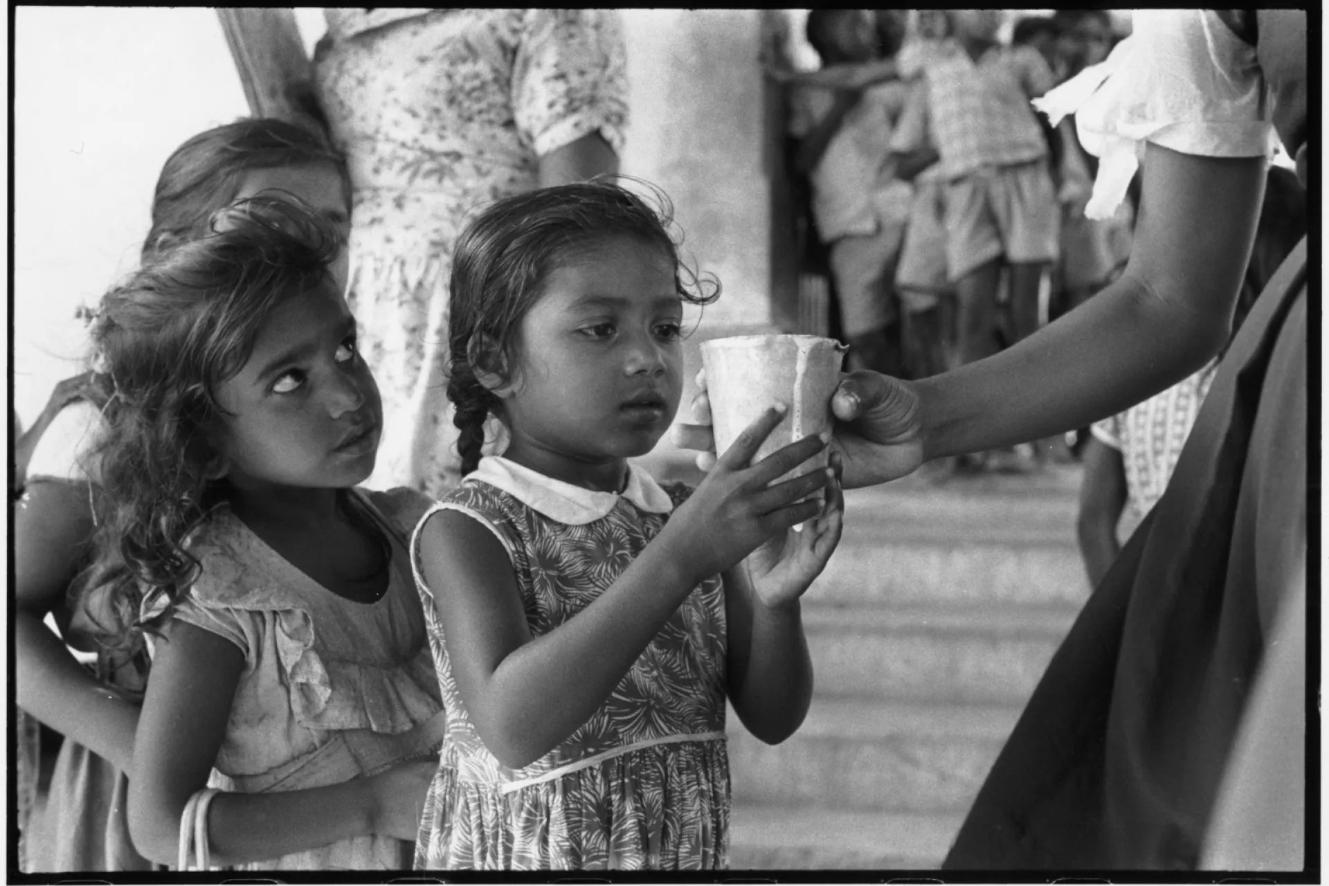A girl receives a glass of milk