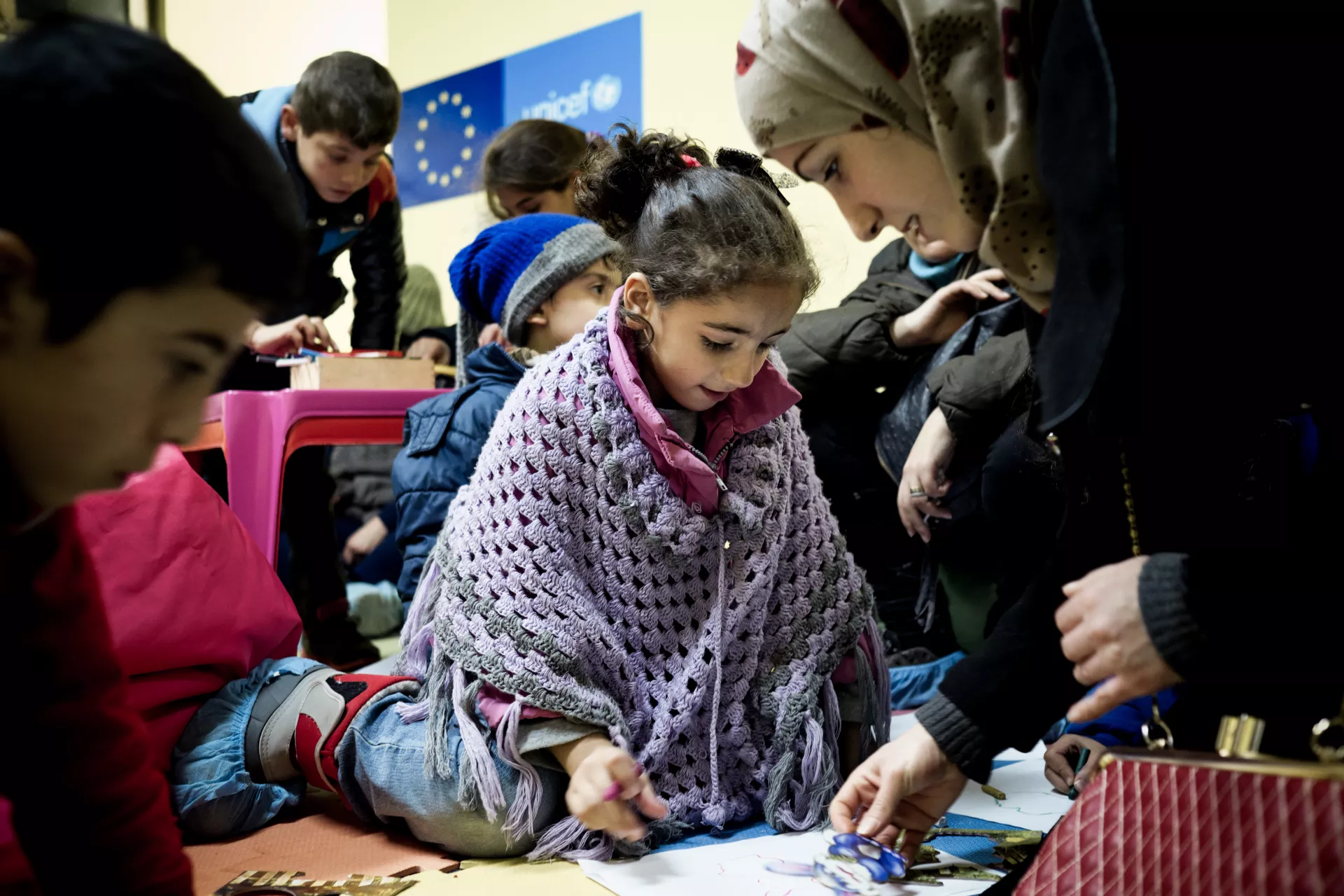 Jannat Raslan, 7, a refugee from the destroyed Syrian Arab Republic City of Homs, participates in an activity with her mother Amira, 24 , beside her, at a UNICEF-supported child-friendly space in &Scaron;id, before taking a train into Croatia.