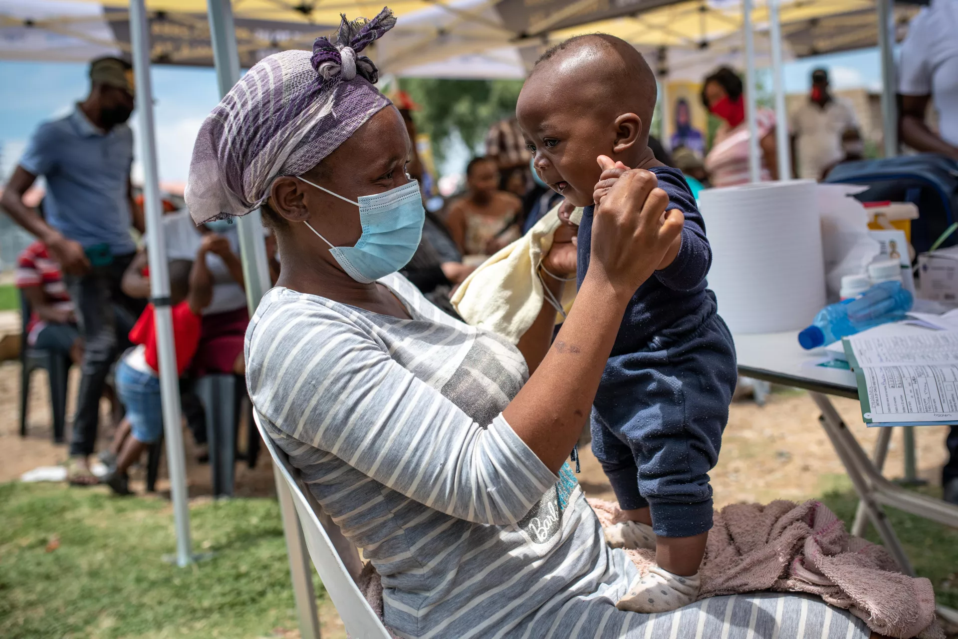Mother Neliswa Mnana holds her son, 6-month-old Phatu Mnana, at a pop-up vaccination site run by the Zwakala campaign.