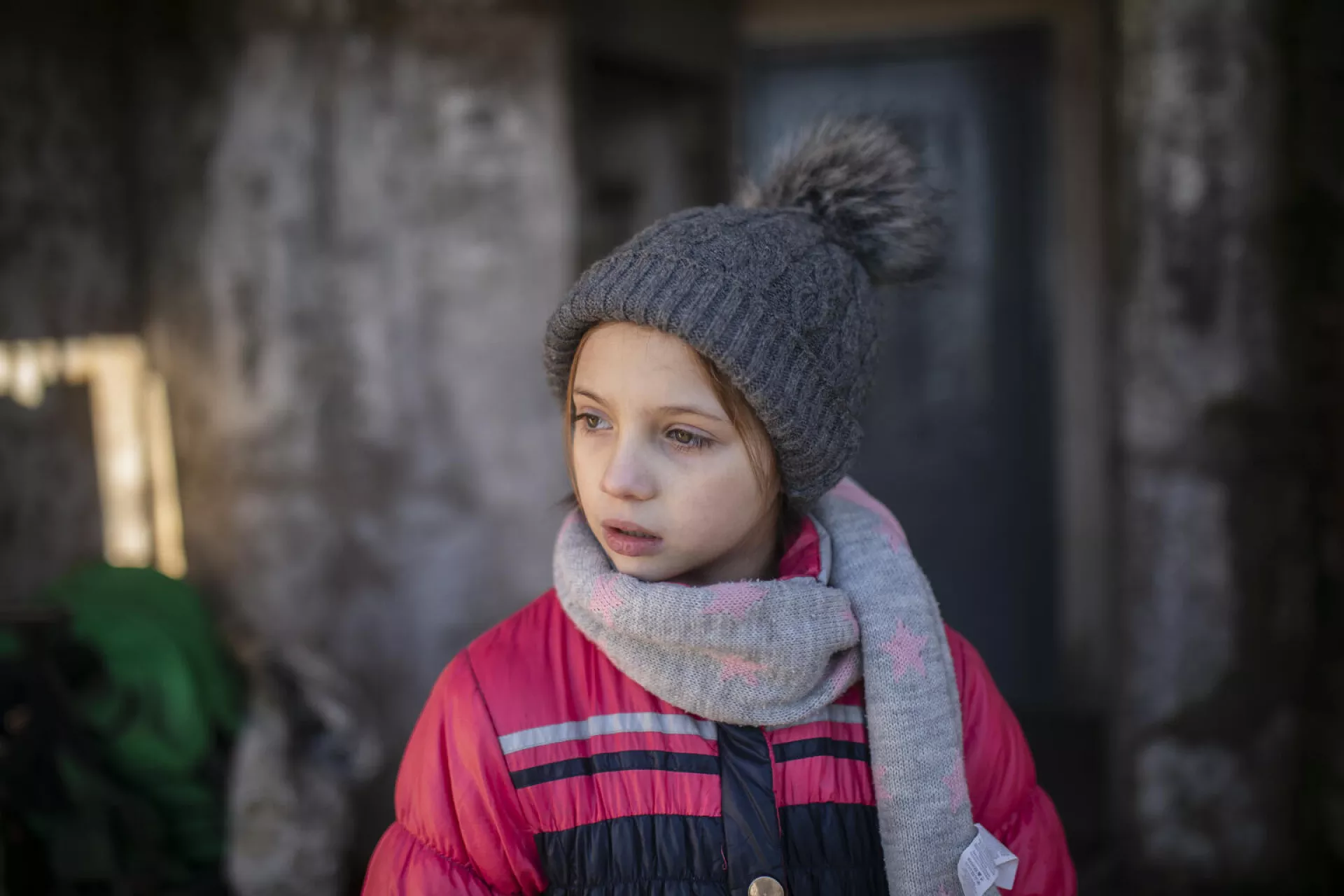 9-year-old Masha stands in the entryway of her home in eastern Ukraine