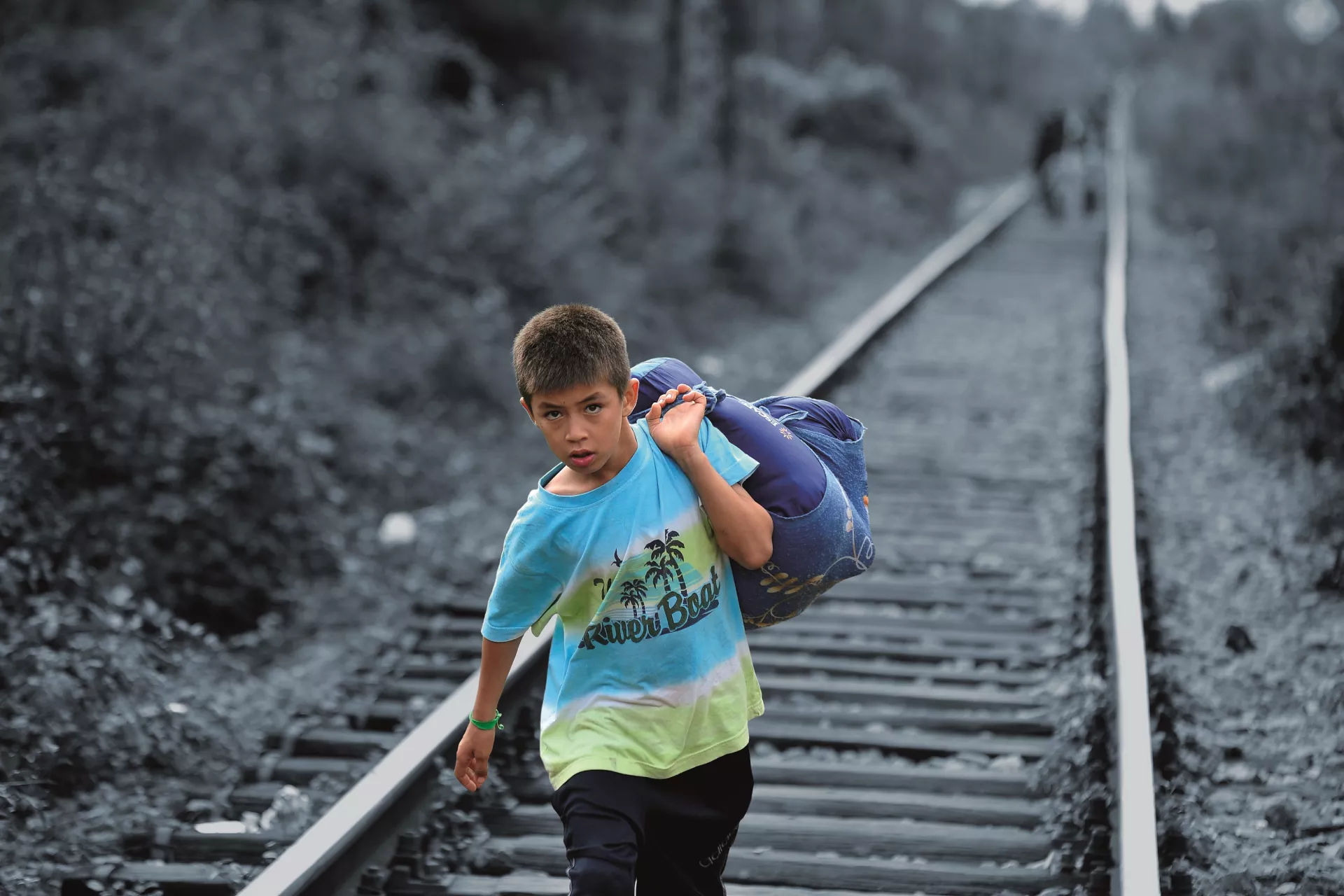 Serbia. A boy carrying his belongings in a large cloth bag over his shoulder crosses from the former Yugoslav Republic of Macedonia.