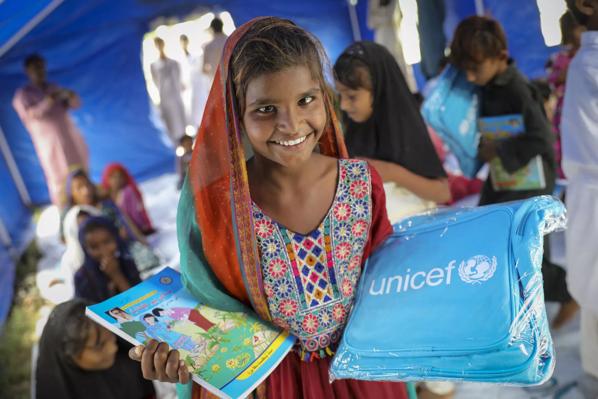 Una niña recibe una mochila y libros de UNICEF como parte de la respuesta de emergencia para apoyar a los niños afectados por las inundaciones en Pakistán en 2022.
