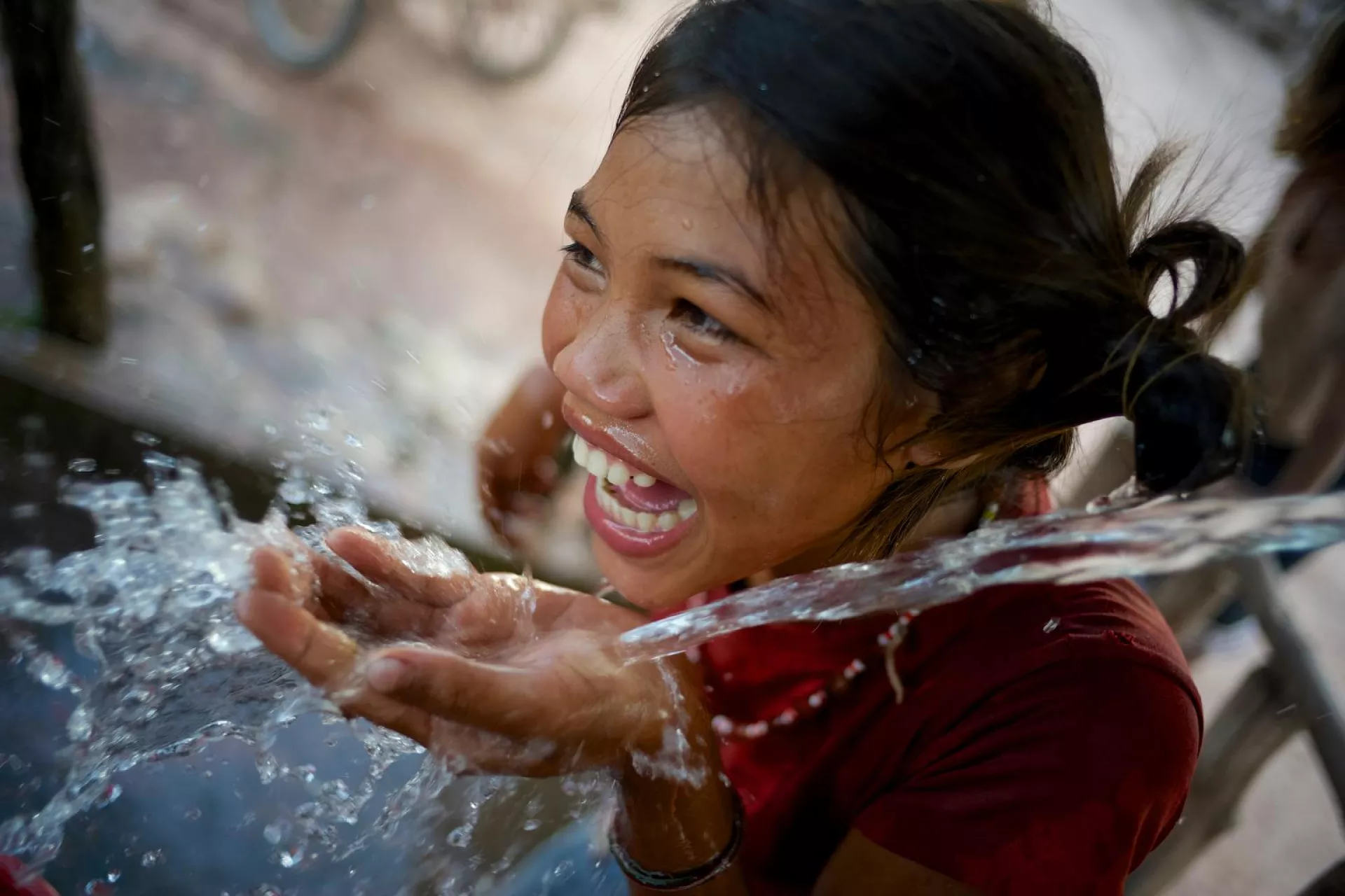 Pure joy: A girl in Laos drinks from a water installation that UNICEF built in her village.