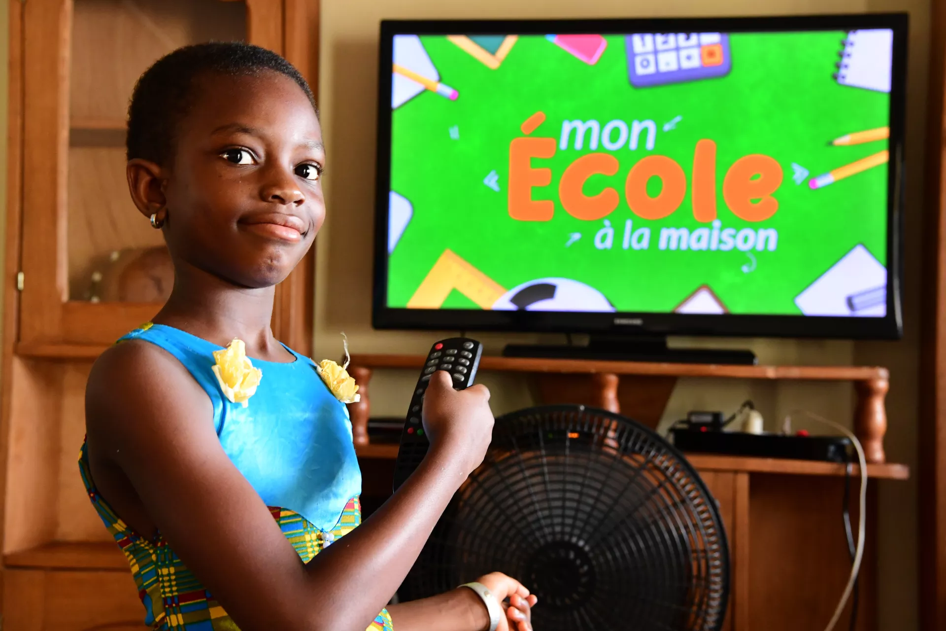 Côte d'Ivoire. A girl points at a TV screen.