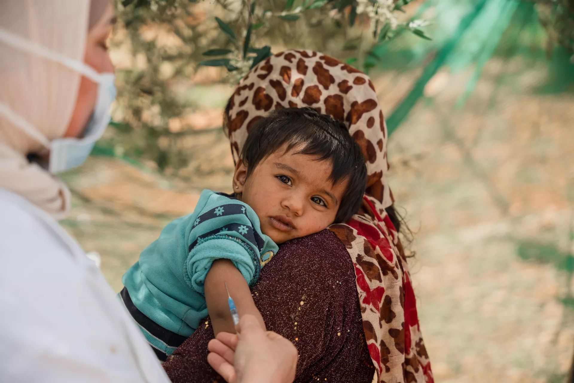 Eight month old Fatema receives a vaccine at a mobile immunization clinic in Jordon. 