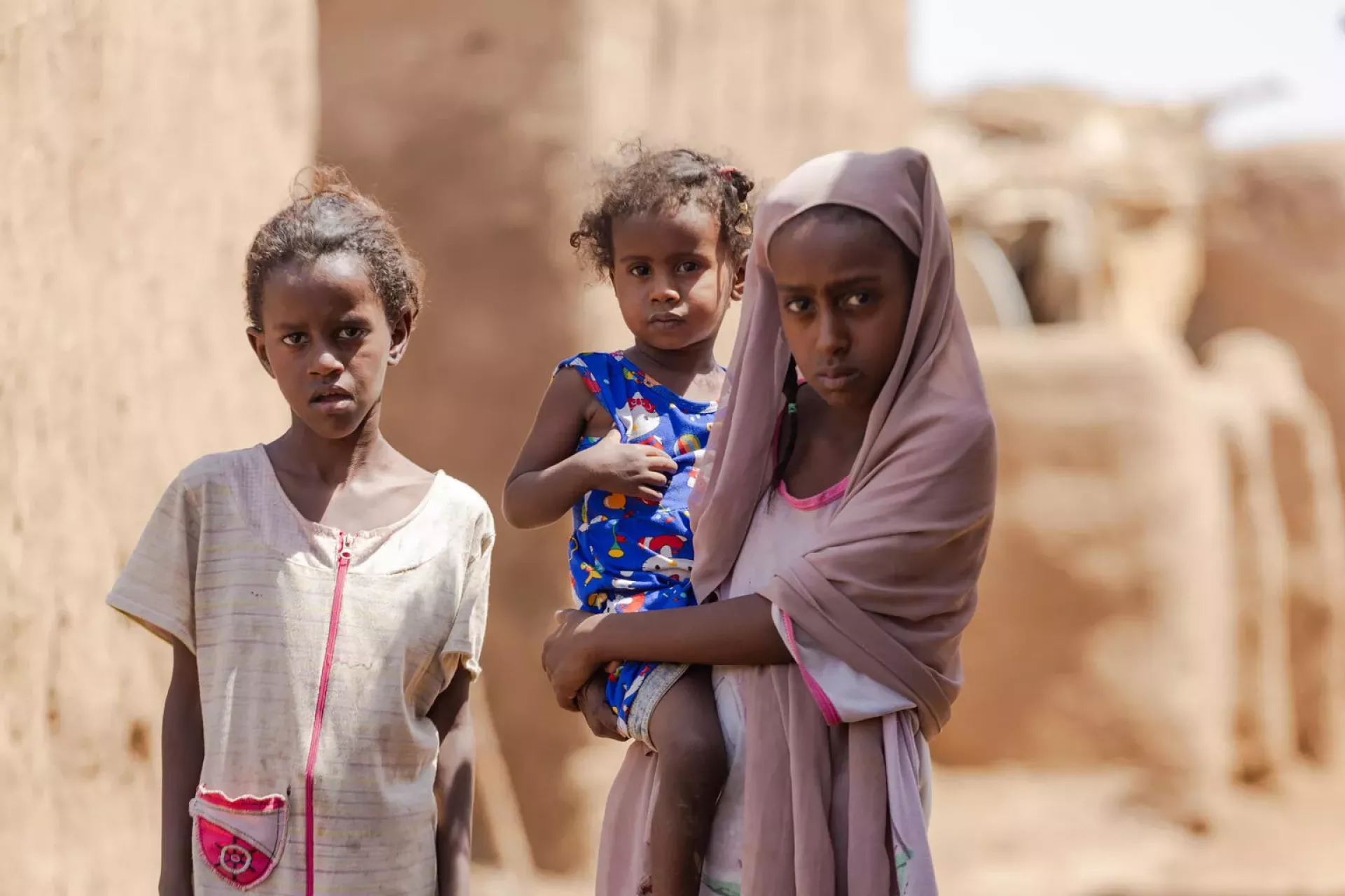 Sudan. A girl holds a young child in the Alsabaat community.